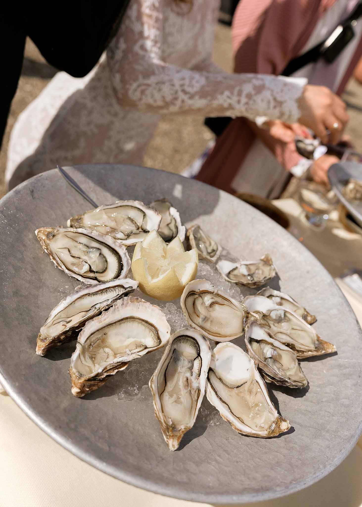 Fresh oysters with lemon served during wedding reception dinner service