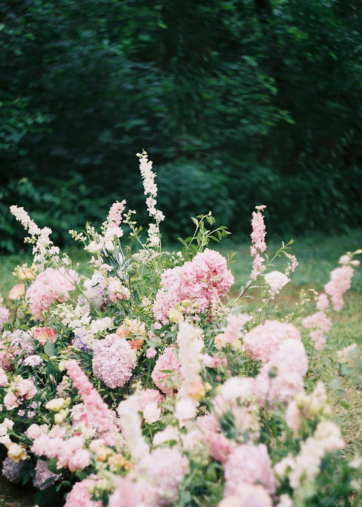 Close-up of pink and white floral arrangement in outdoor garden wedding setting