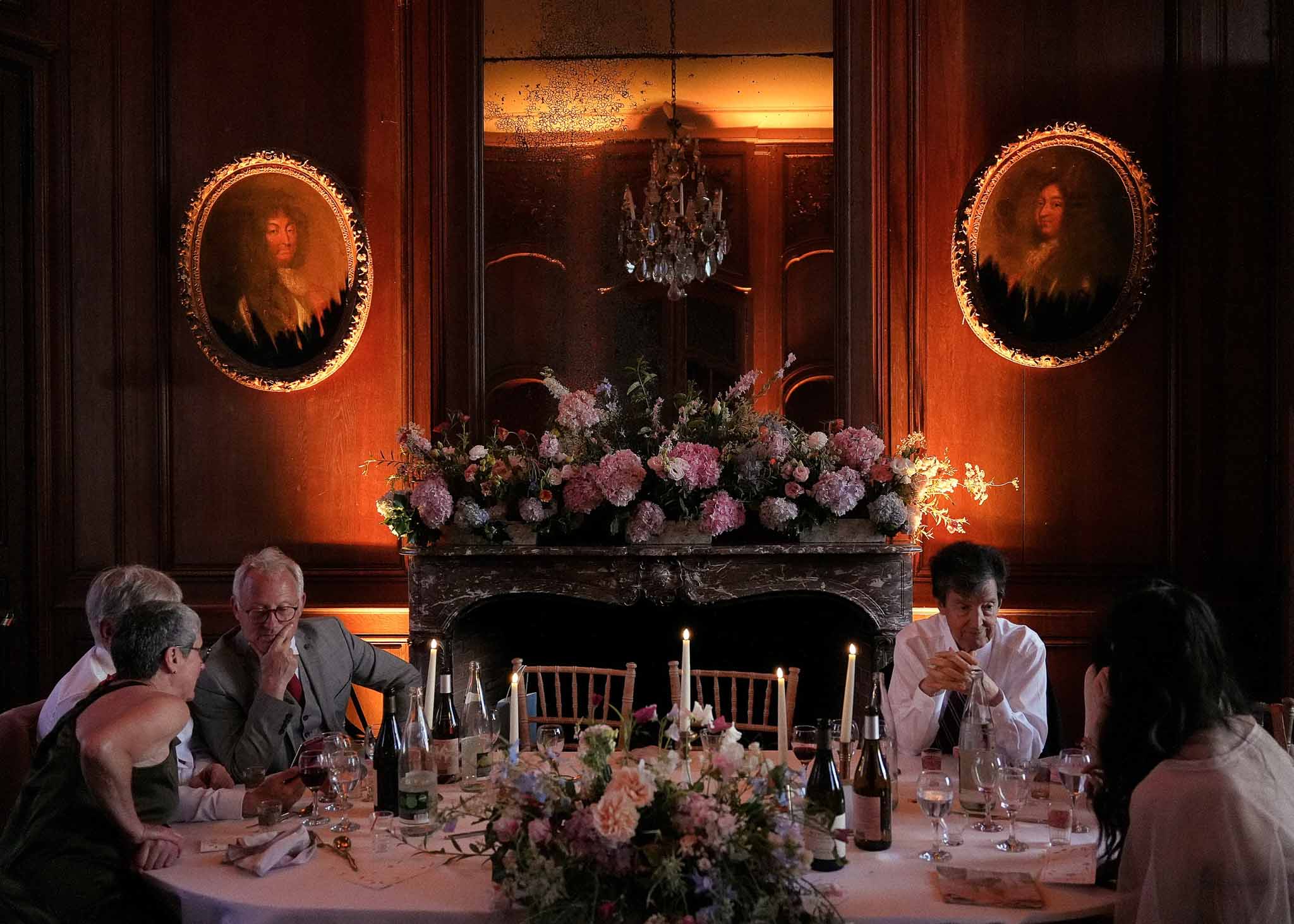 Formal reception dinner with blush linens and floral arrangements in ornate interior dining room