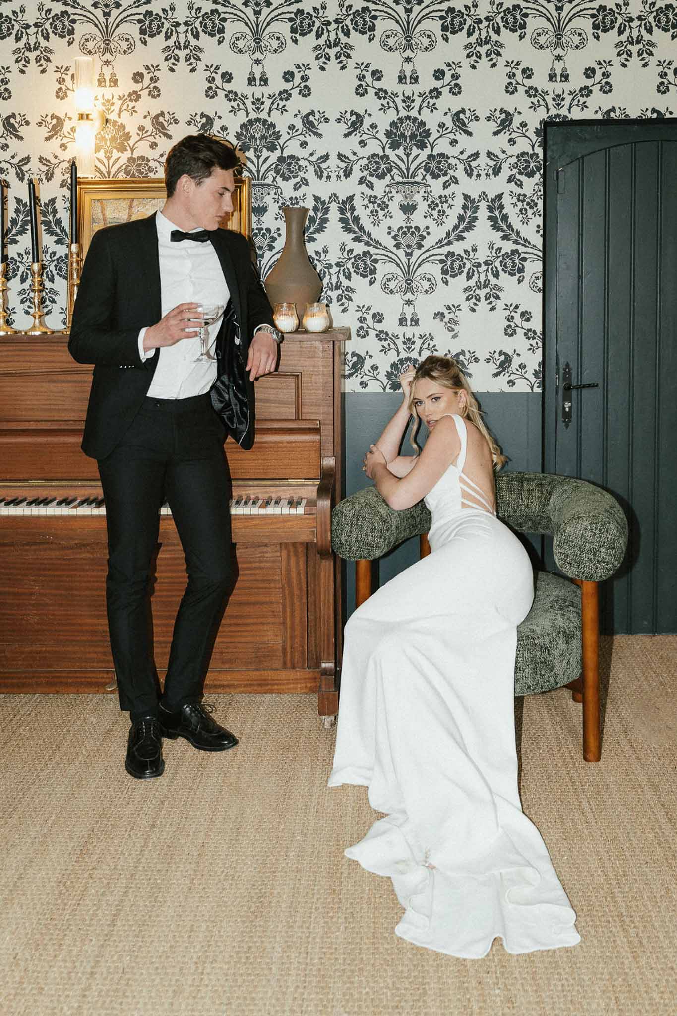 Bride and groom sharing intimate moment in formal interior with damask wallpaper during wedding reception