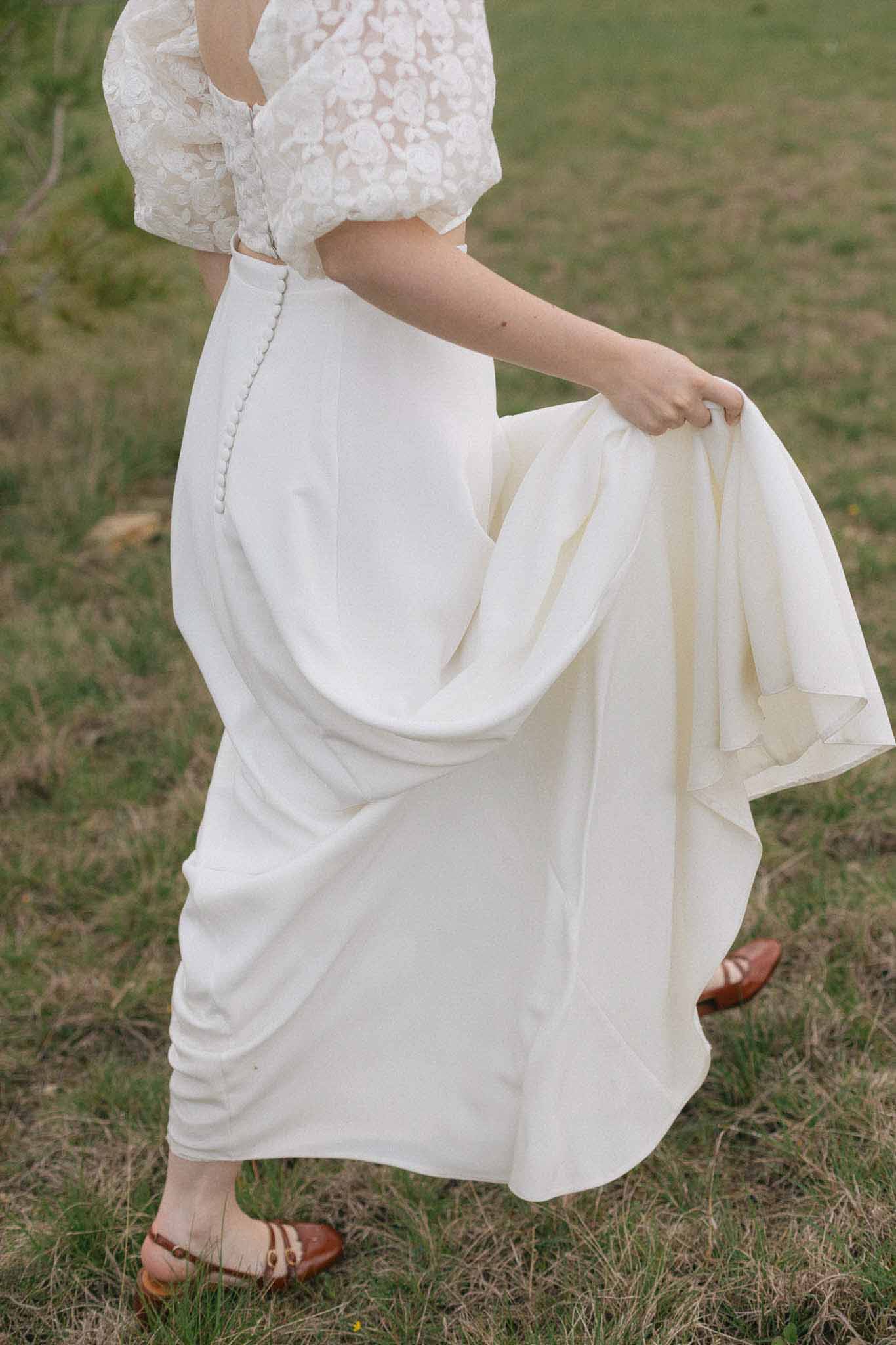 Bride showing wedding dress silhouette in outdoor garden setting