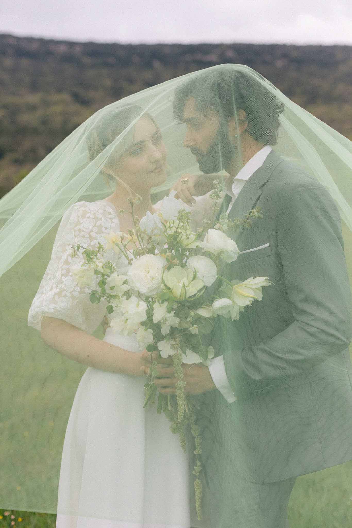 Bride and groom intimate portrait with bouquet in forested outdoor setting