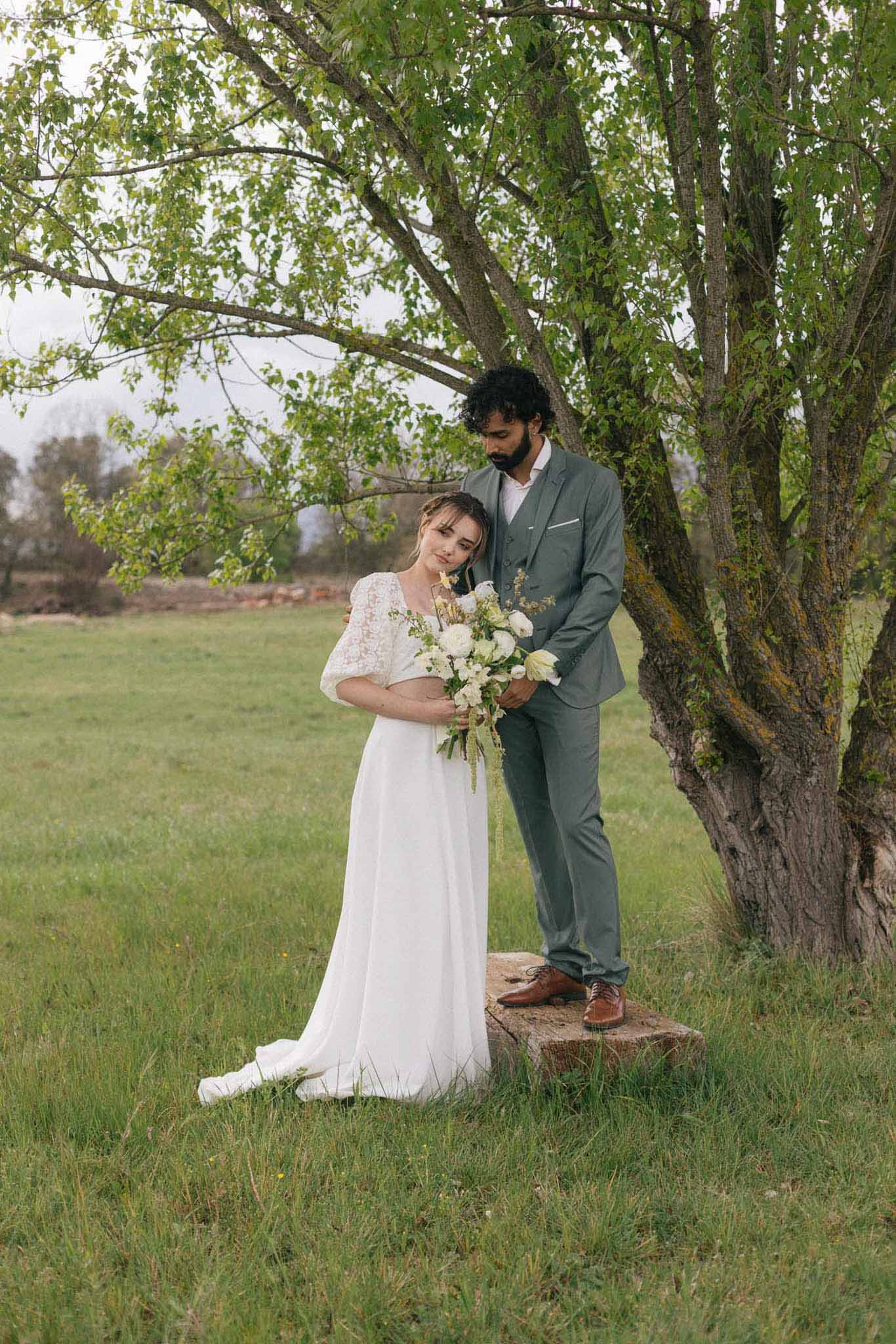 Bride and groom portrait beneath willow trees in pastoral garden setting