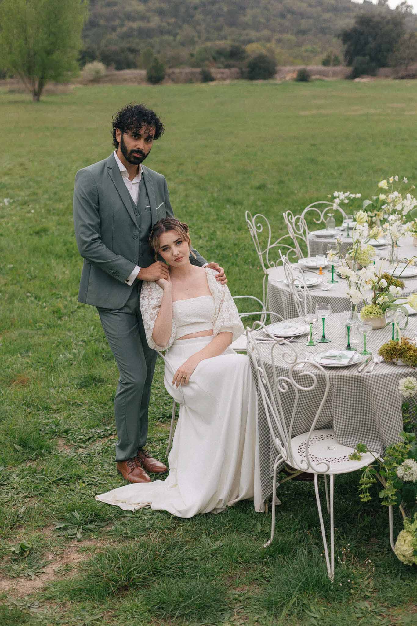 Bride and groom portrait at outdoor meadow reception with elegant table setting