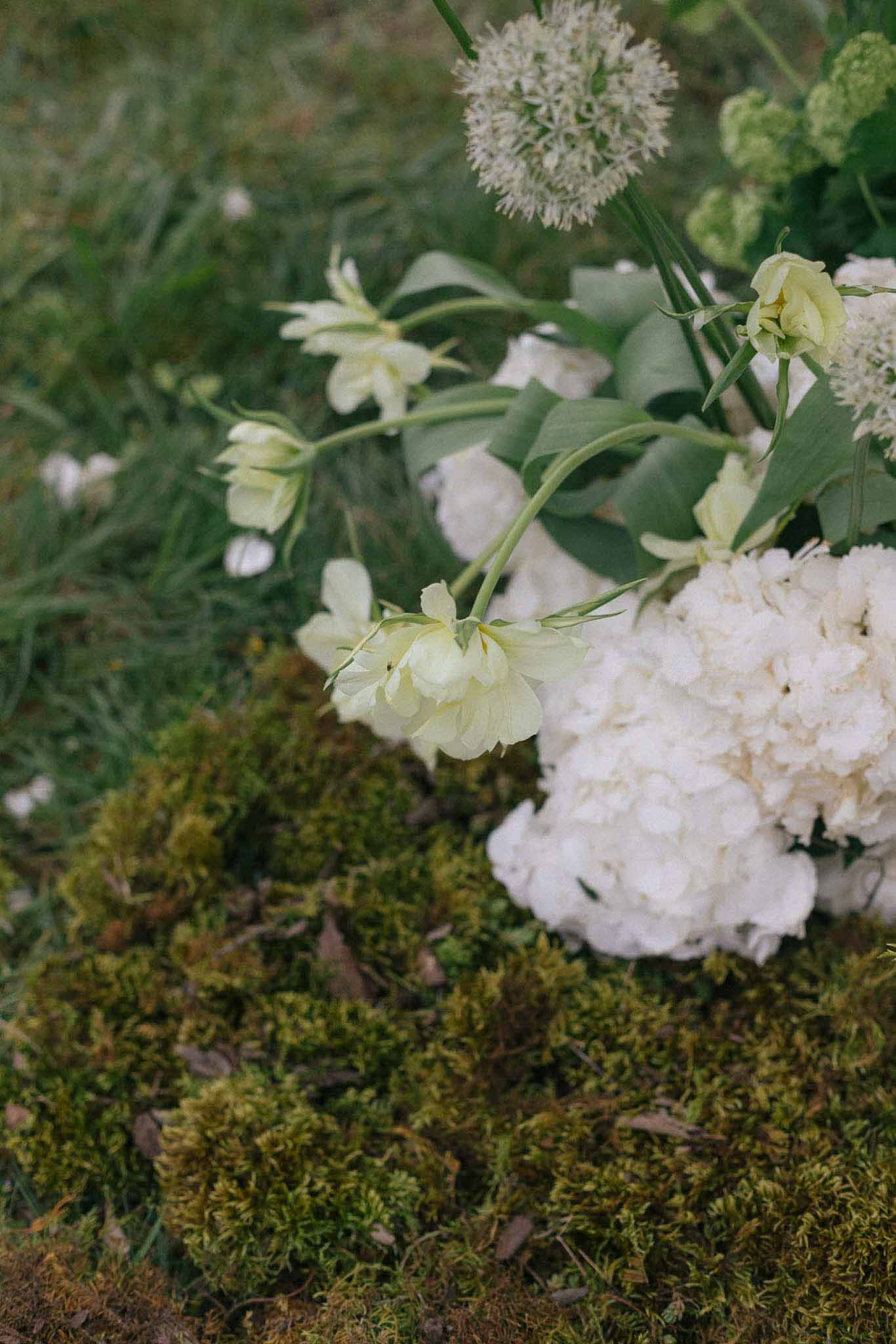 Close-up of ivory peonies, ranunculus, and white hydrangeas in garden-inspired wedding floral arrangement