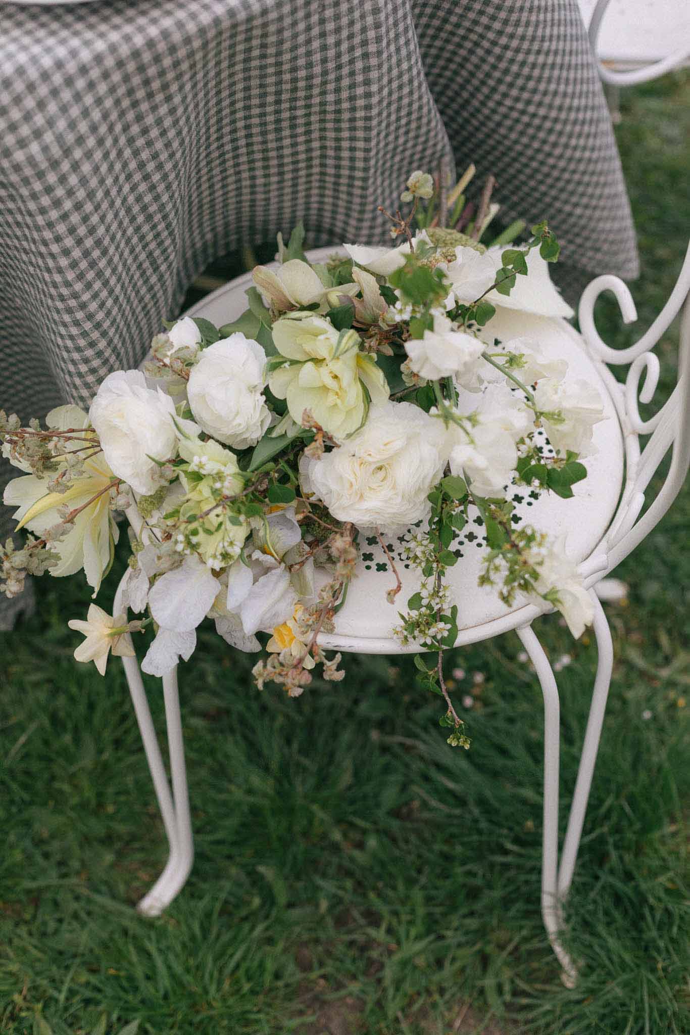Bridal bouquet arrangement with cream roses and white flowers in decorative bowl at outdoor wedding