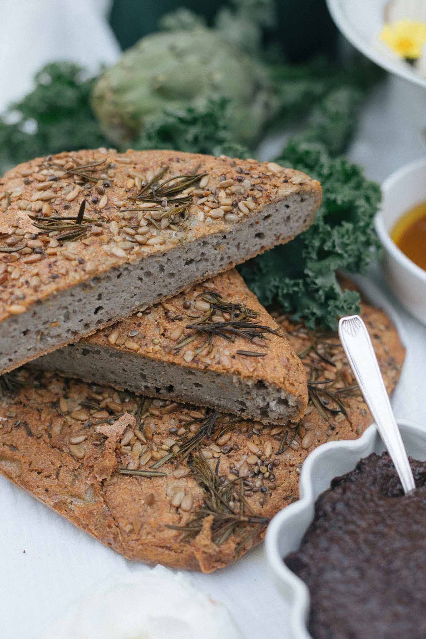 Artisanal bread appetizer display with rosemary garnish and olive oil at wedding cocktail hour