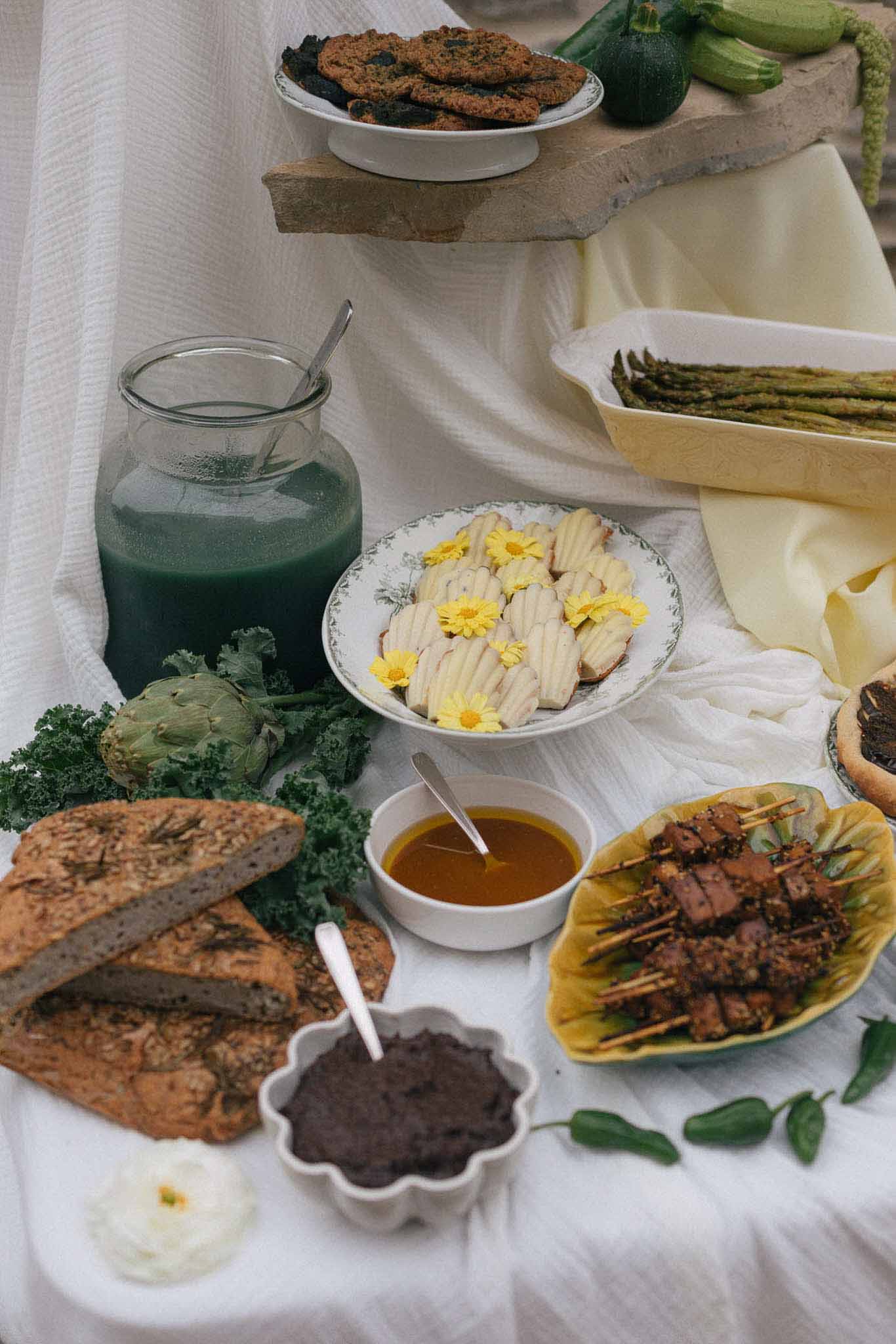 Farm-to-table wedding reception food display with organic vegetables and artisanal dishes on white linens