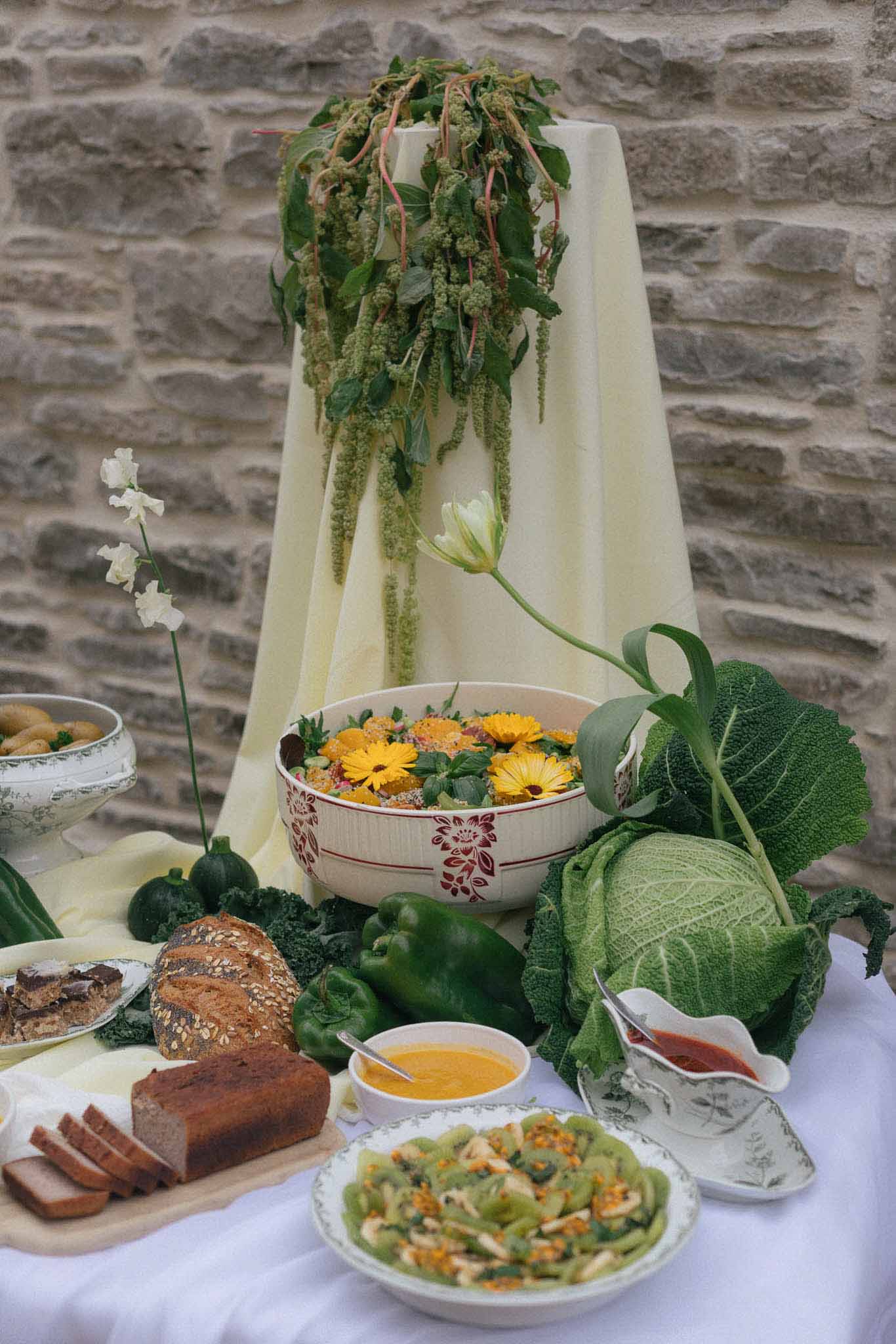 Rustic wedding food display with flowers and greenery at countryside venue
