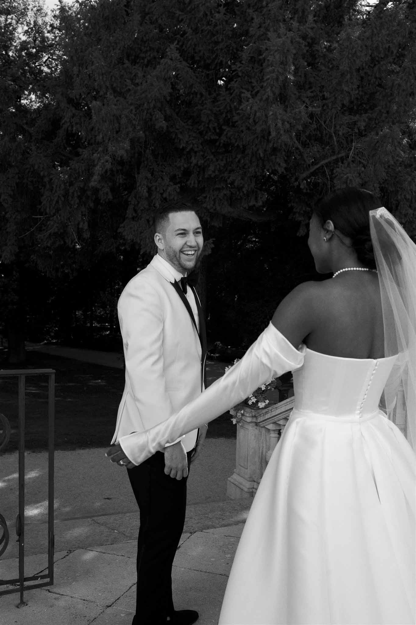 Black and white couple portrait with groom looking at bride in outdoor garden setting