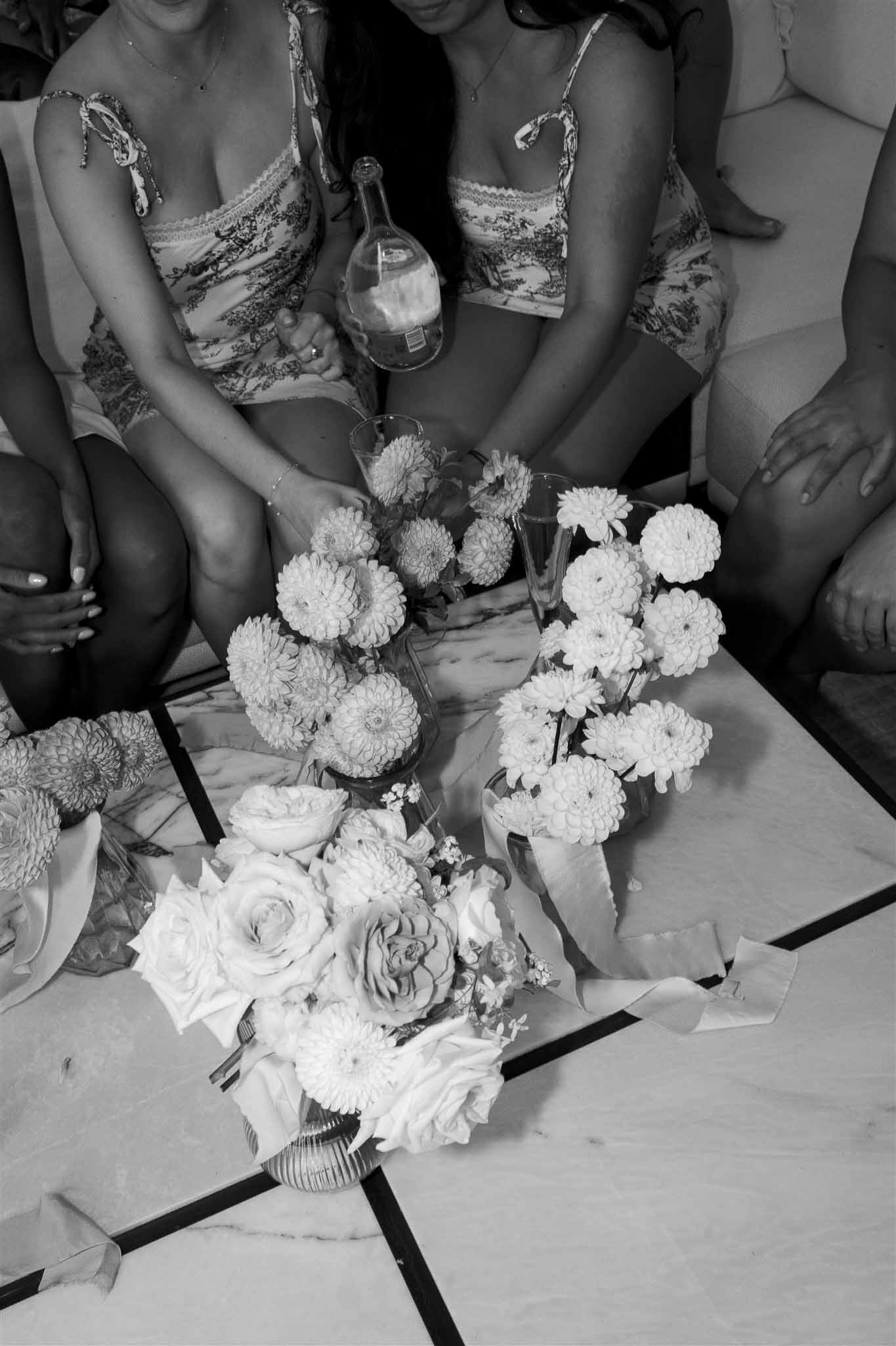 Bridal party with champagne glasses and bouquets in black and white overhead shot at wedding reception