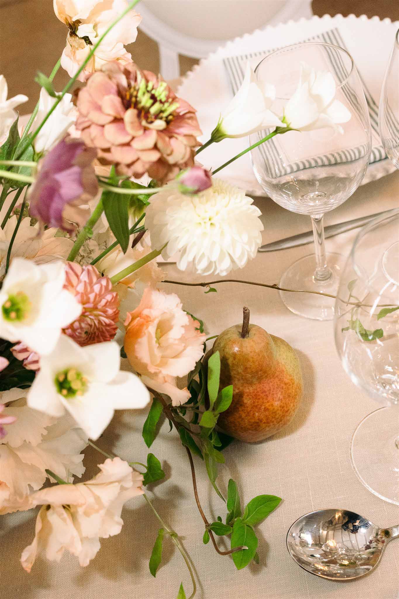 Reception table centerpiece with mixed flowers and place setting at wedding venue