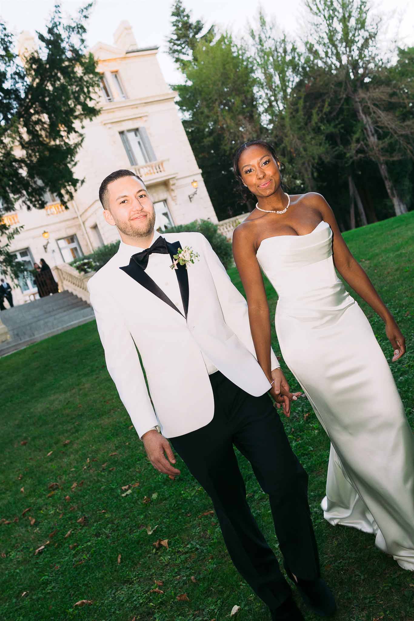 Formal bride and groom portrait on lawn of classical estate with neoclassical villa background