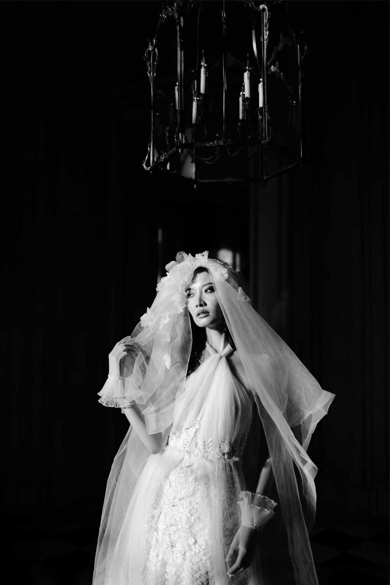 Black and white bridal portrait with chandelier lighting in indoor setting