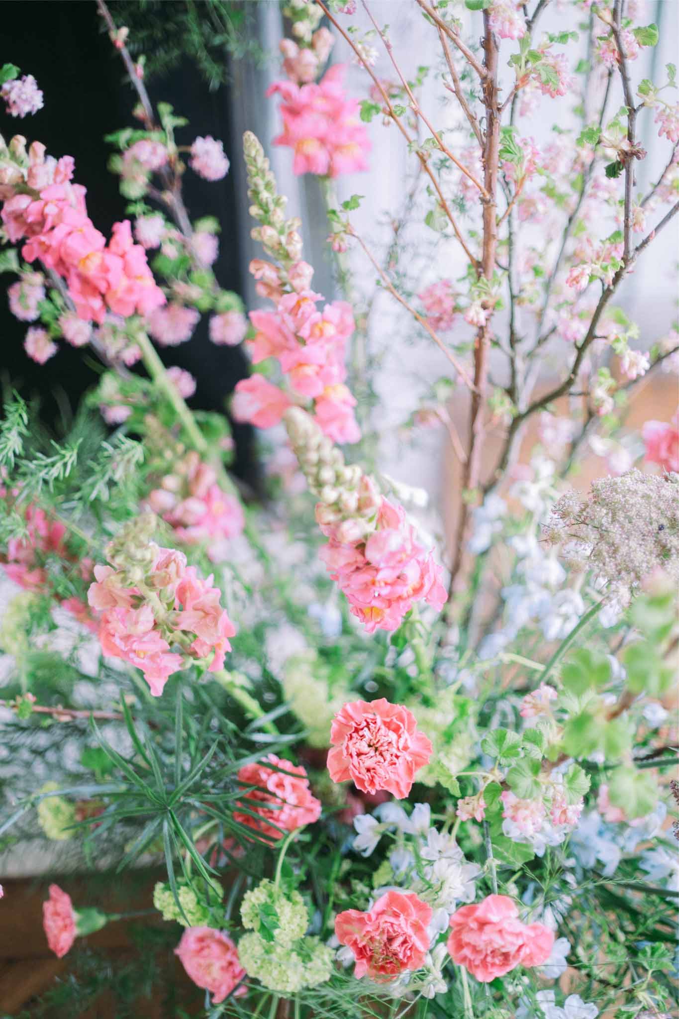 Coral and pink garden rose floral arrangement with Queen Anne's lace at romantic wedding venue
