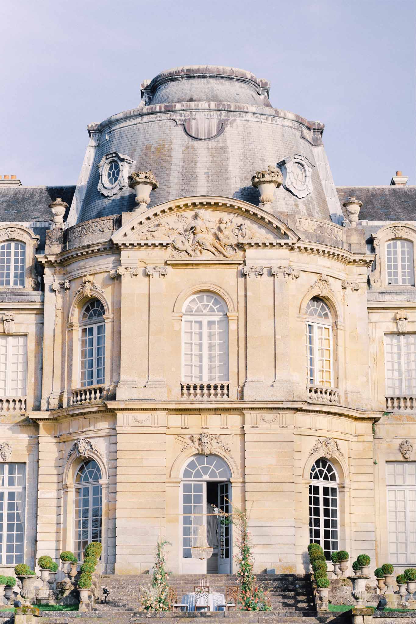 Classical stone château pavilion with neoclassical architecture and mansard roof at French wedding venue