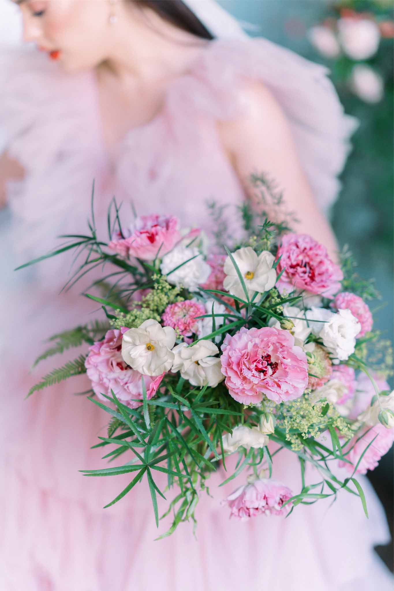 Close-up of pink peony and white rose bridal bouquet at outdoor garden wedding