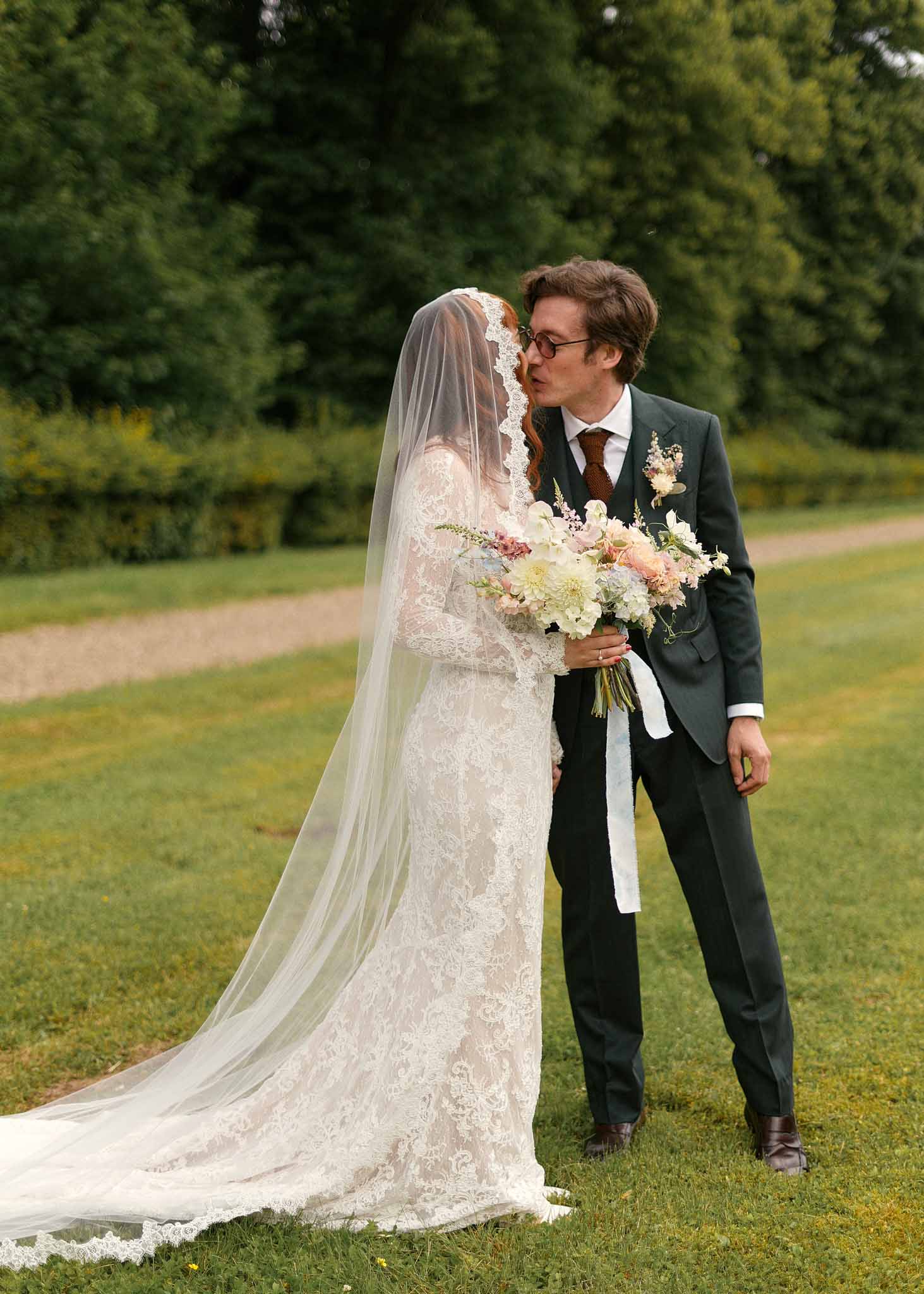 Bride and groom portrait session in garden setting with bouquet and natural outdoor backdrop