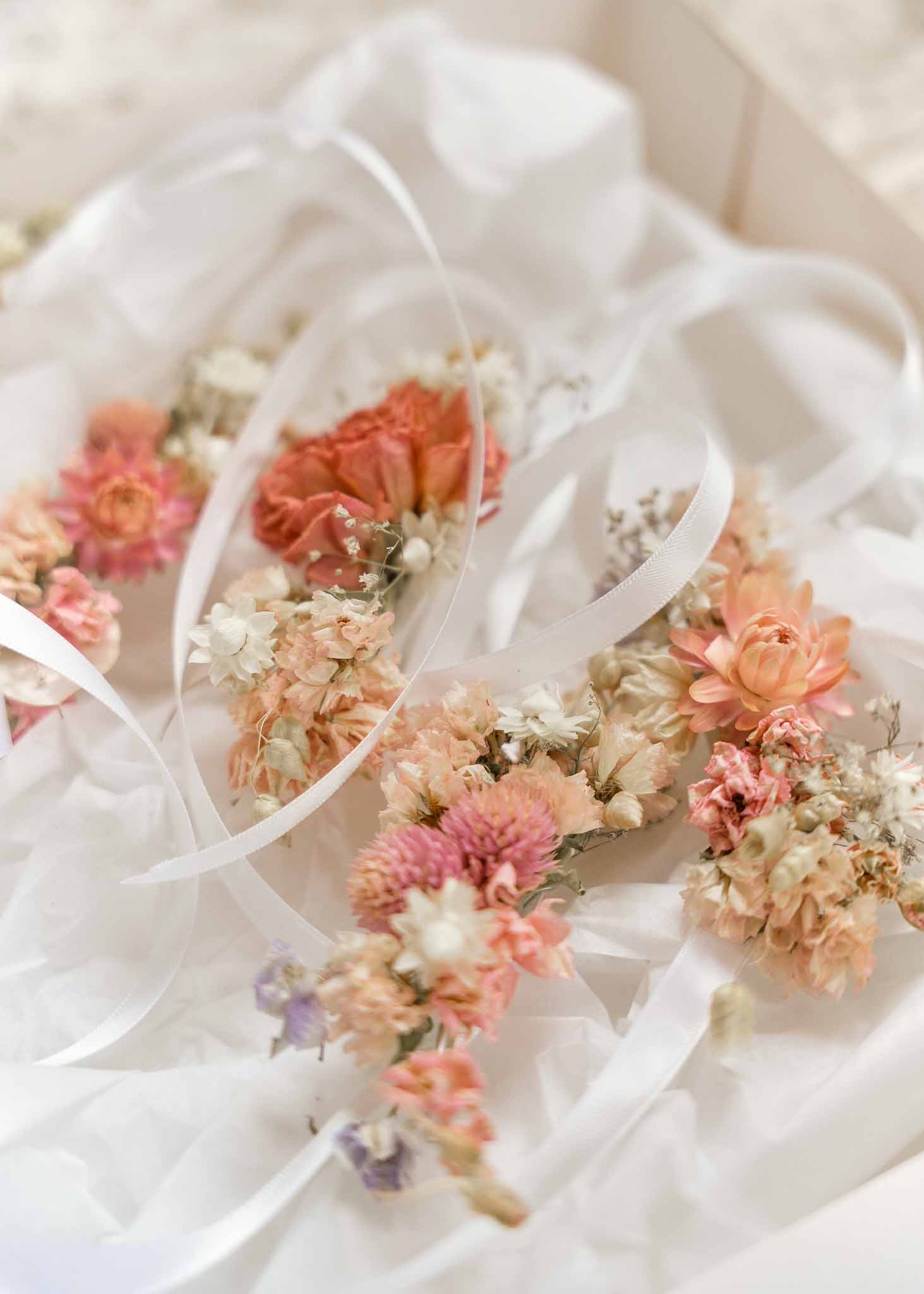 Multiple bridal bouquets with coral dahlias and baby's breath arranged together in close-up detail