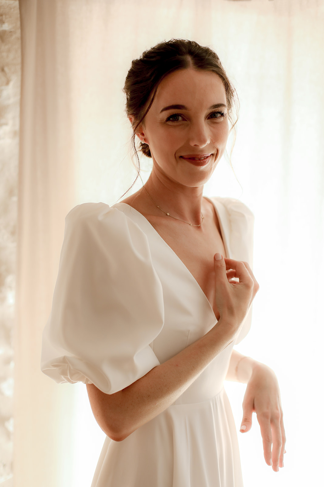 Close-up bridal portrait with cream dress and gold necklace in natural window light