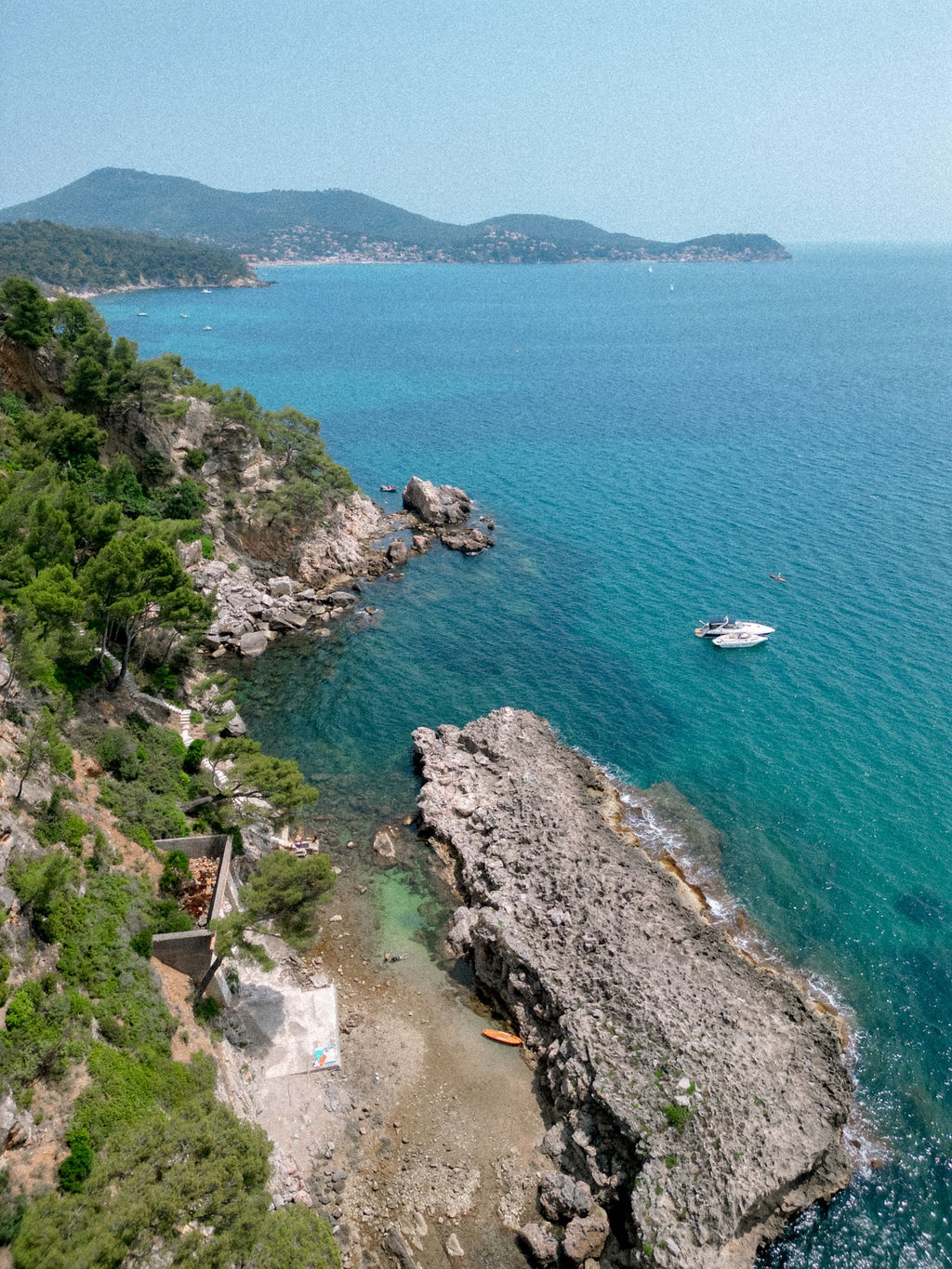 Aerial view of private cove with turquoise waters and rocky coastline at Domaine Rocabella, French Riviera