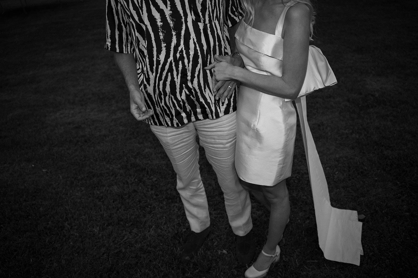 Black and white portrait of bride and guest in intimate moment at outdoor nighttime wedding reception