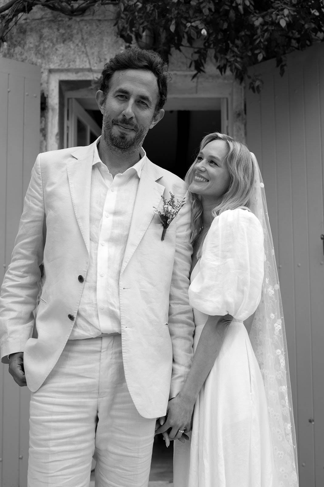 Bride and groom portrait in Mediterranean courtyard with stone building and ivy