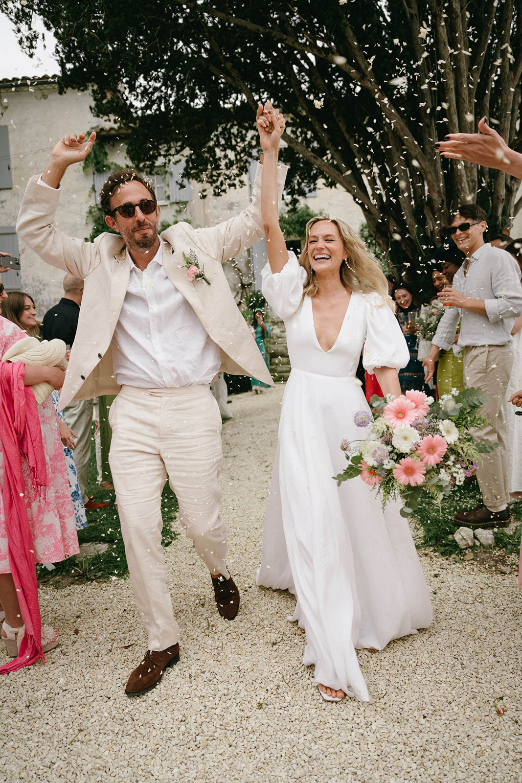 Bride and groom celebrating recessional walk after outdoor ceremony with guests cheering