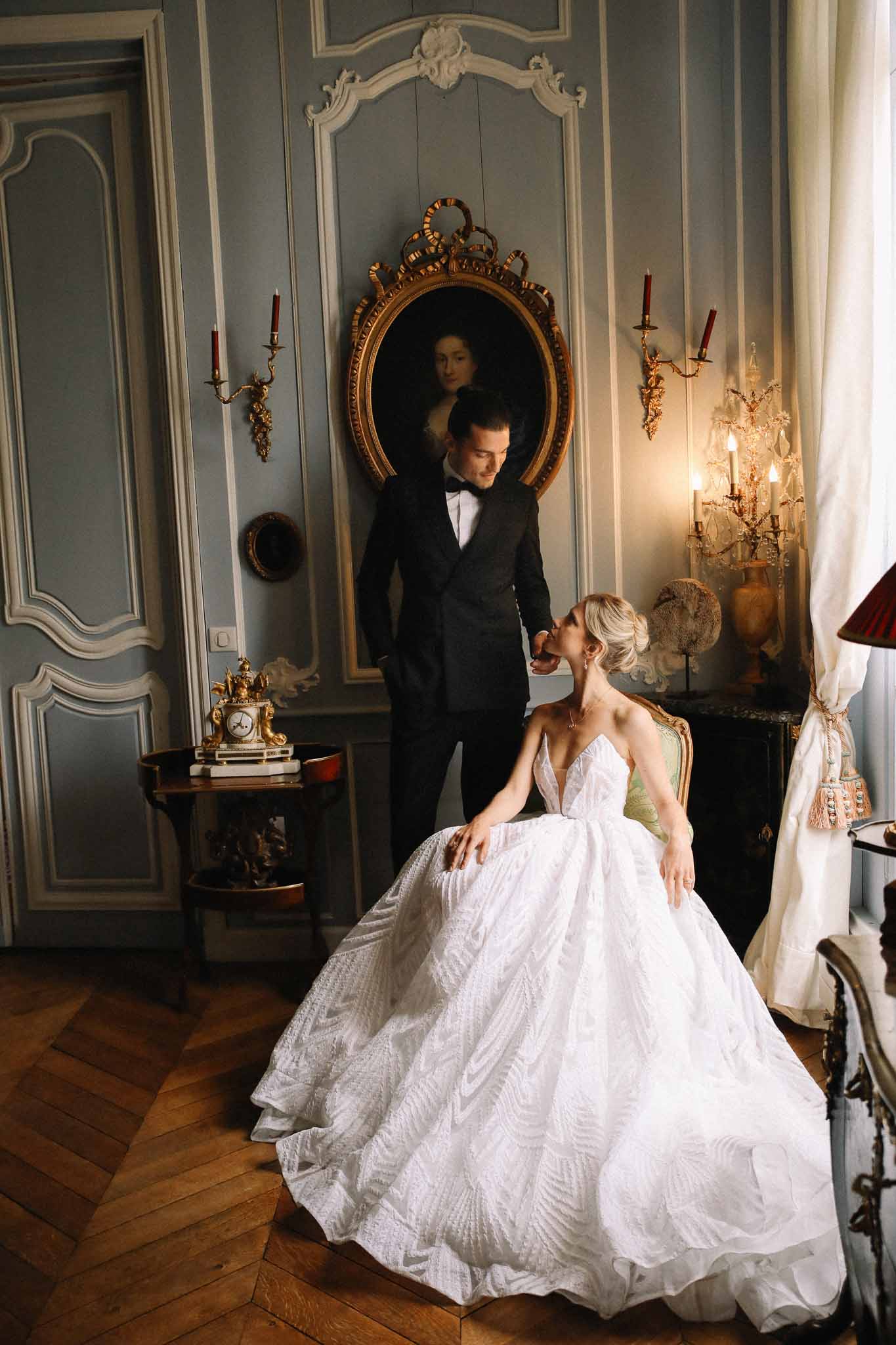 Bride and groom in elegant salon room with classical decor and candlelit ambiance