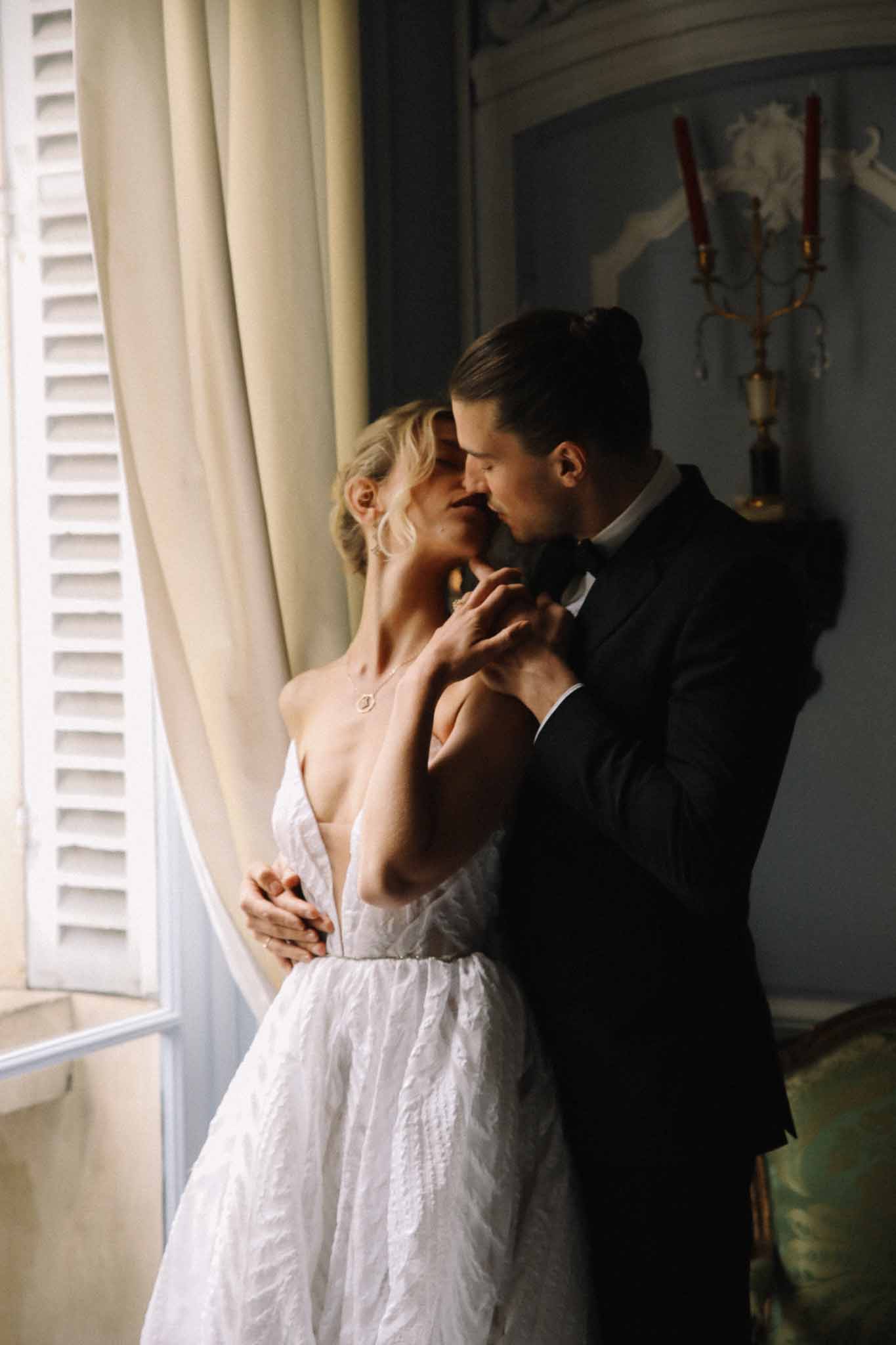 Intimate bride and groom portrait in historic interior with natural window light