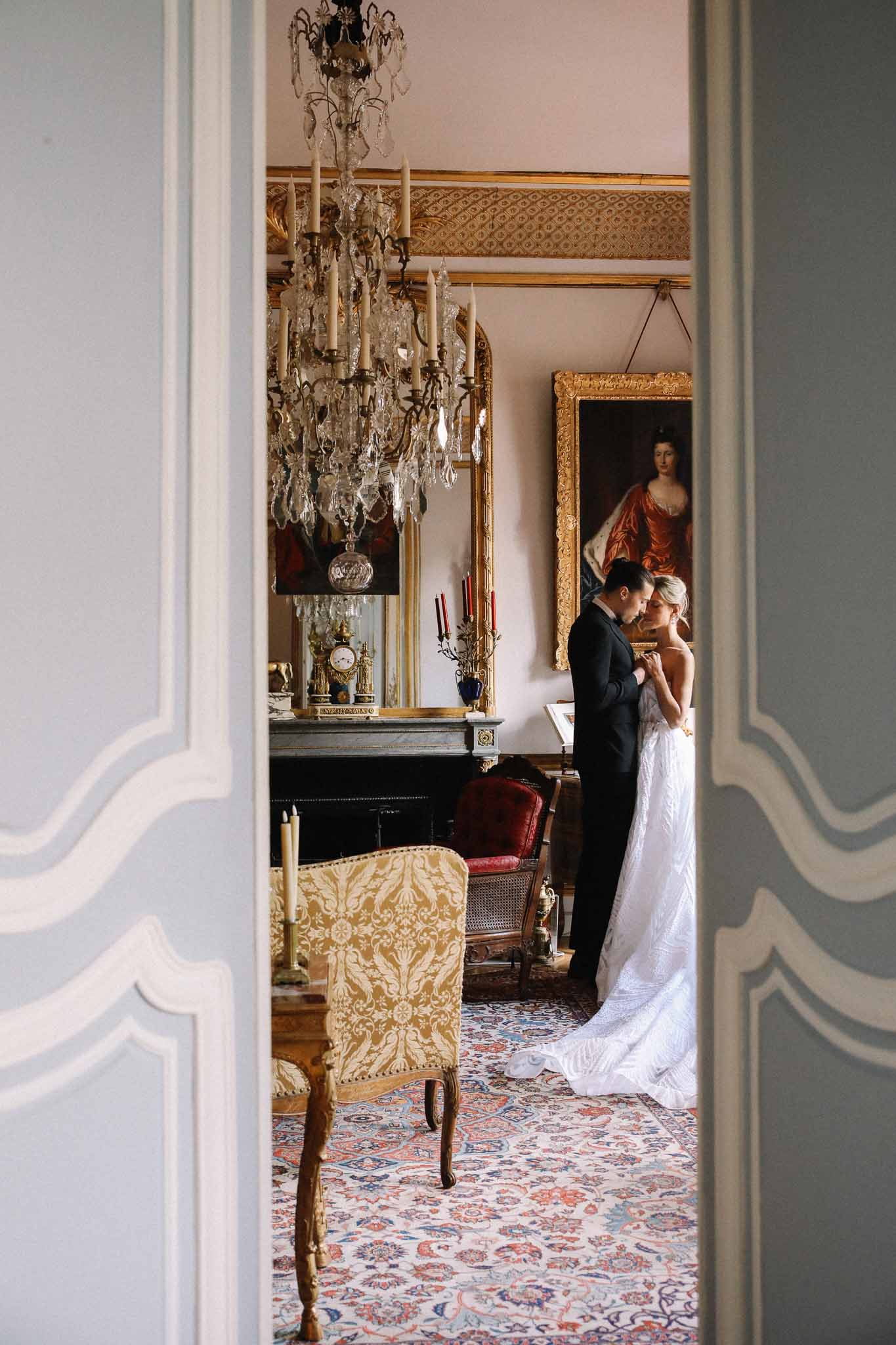 Bride and groom in elegant French interior room with classical architectural details