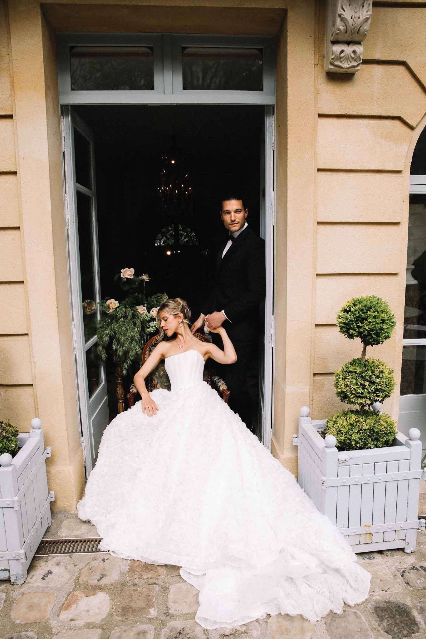 Bride and groom posing in doorway of classical stone building at European wedding venue
