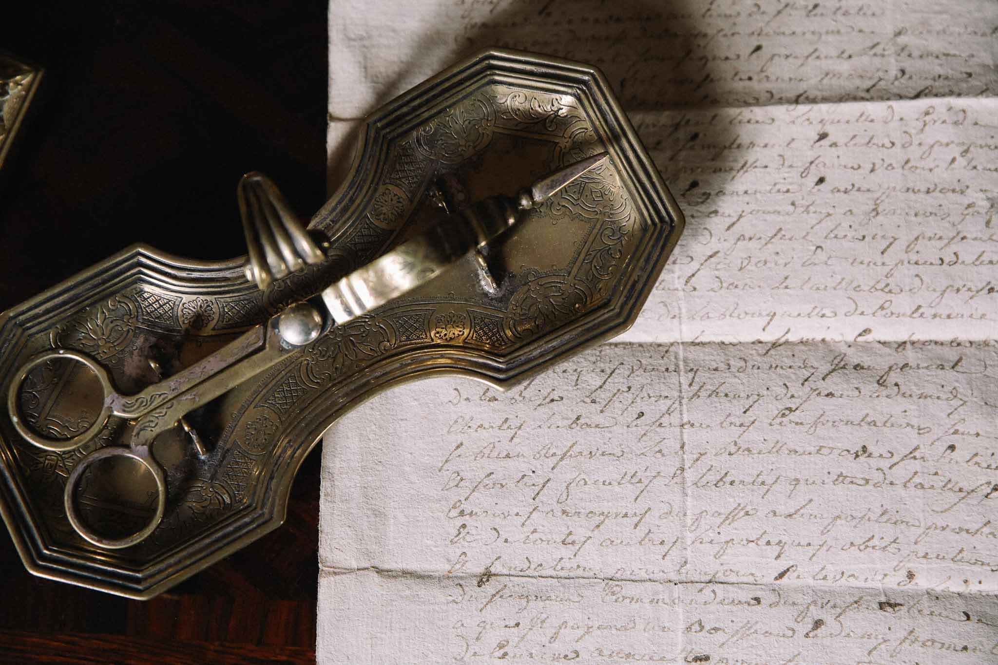 Vintage brass tray with mirrors and decorative comb arranged on handwritten French correspondence