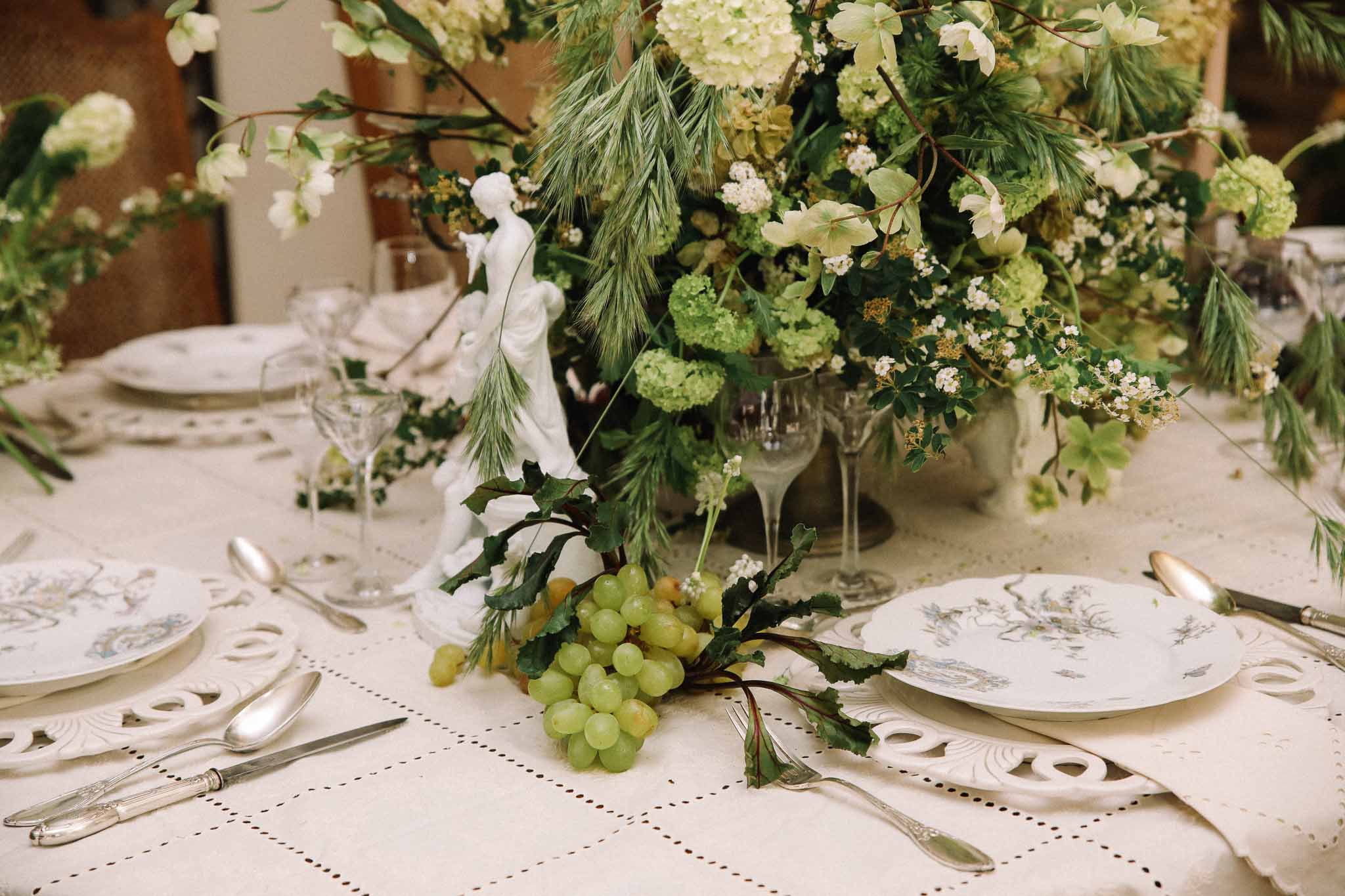 Botanical table centerpiece with hydrangeas and greenery at wedding reception
