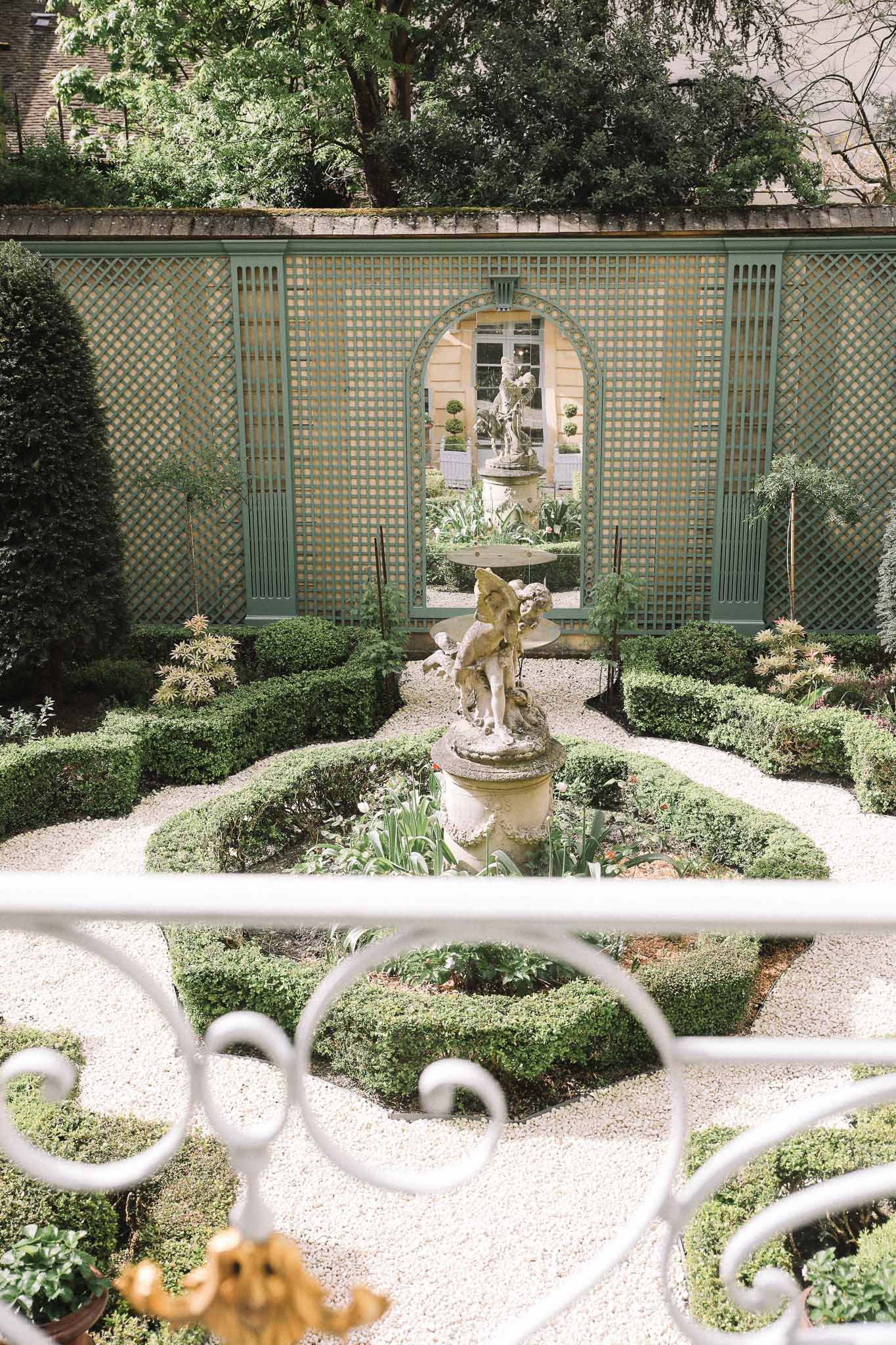 Overhead view of formal garden courtyard with classical statue and geometric hedges at wedding venue