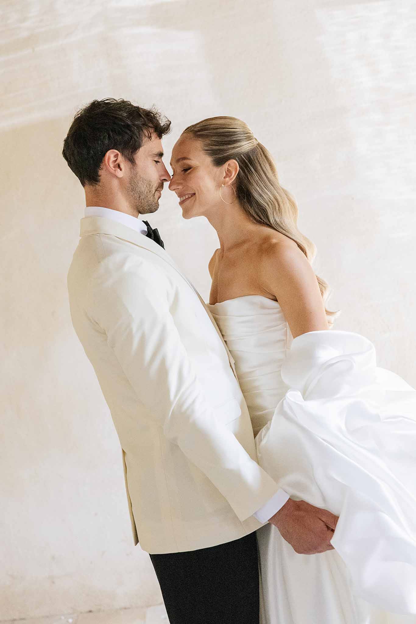 Bride and groom formal portrait in ivory and white wedding attire indoors