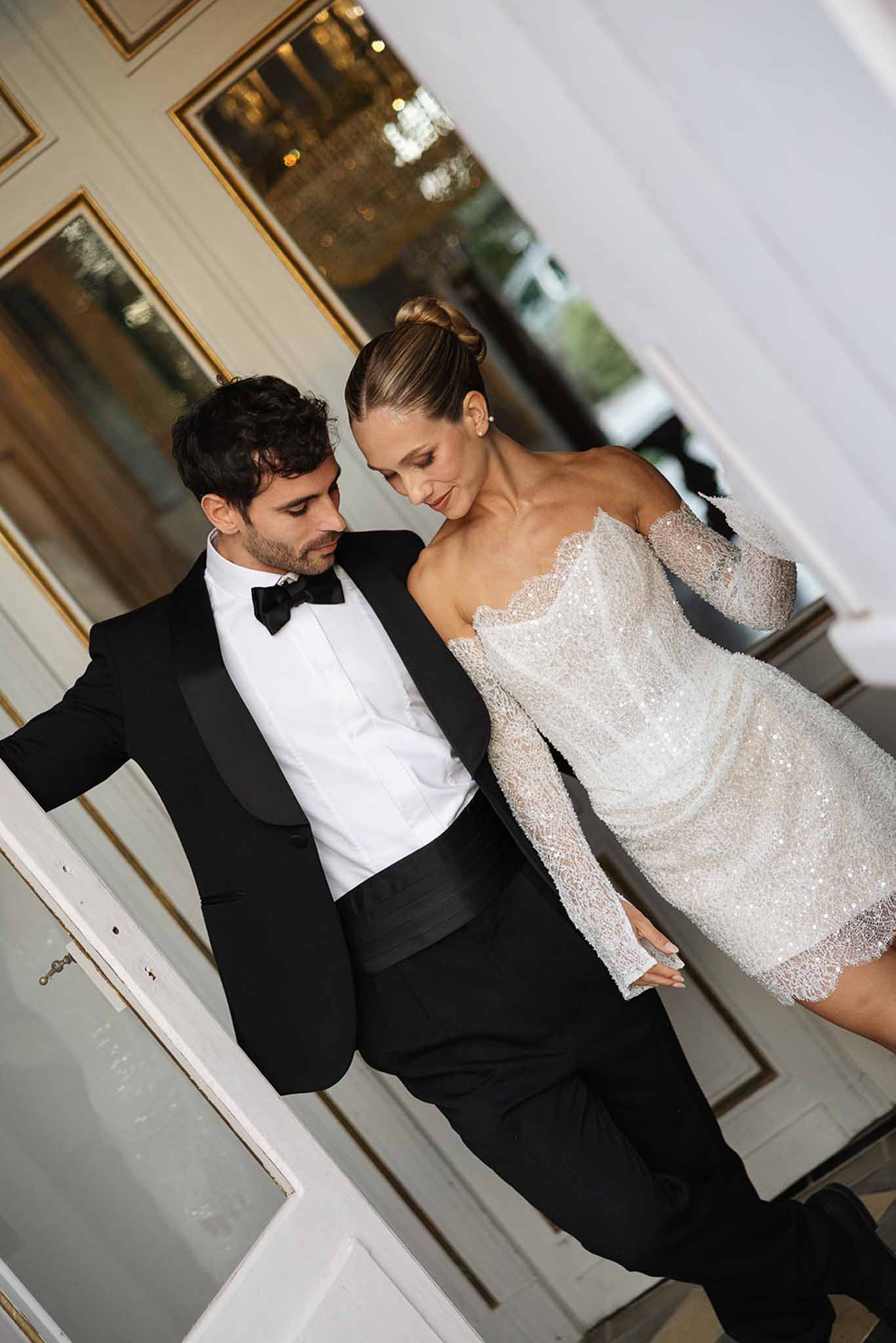 Bride and groom sharing intimate moment in elegant indoor hallway during wedding reception