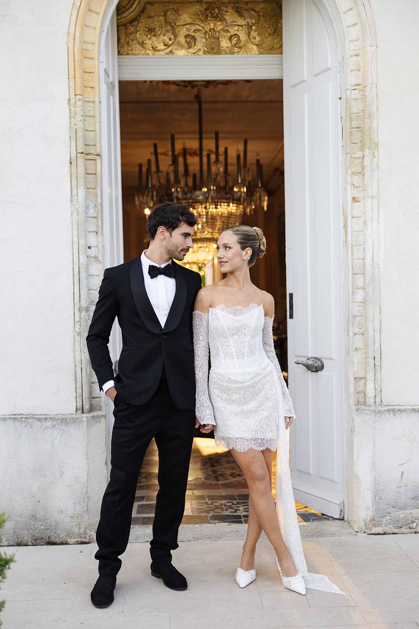 Bride and groom in elegant doorway entrance at neoclassical wedding venue