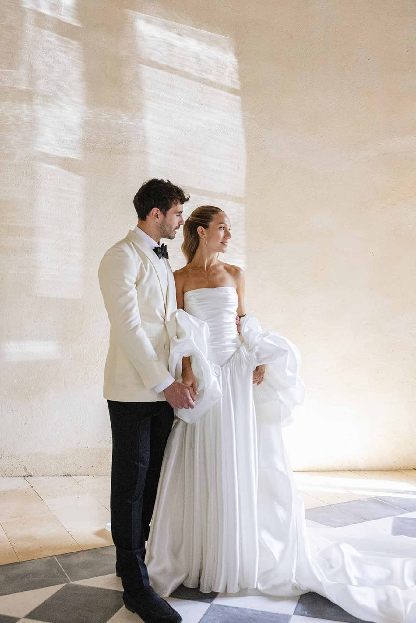 Bride and groom formal portrait in modern indoor venue with neutral decor and natural light