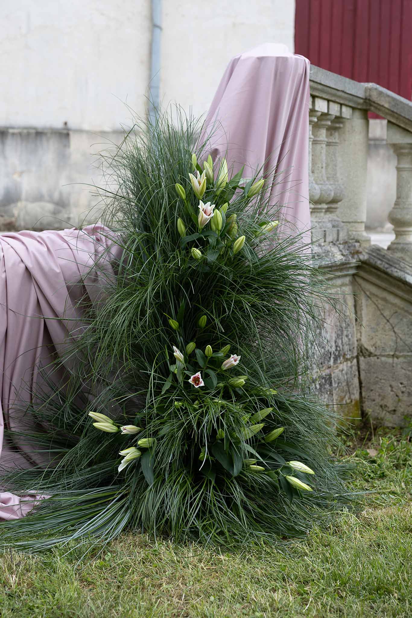 White and blush tulip bridal bouquet with ornamental grass at historic garden estate
