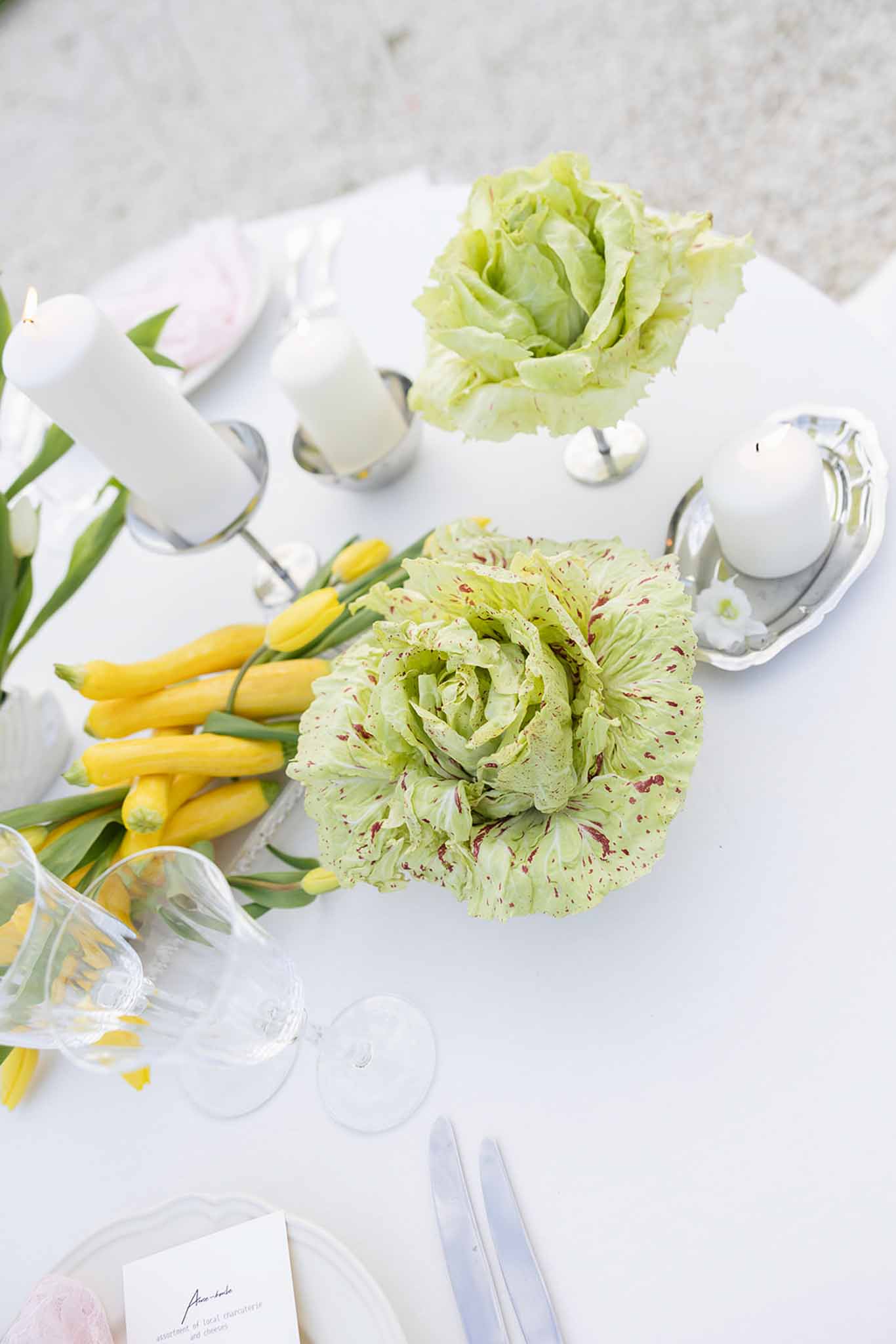 Wedding table setting flat lay with lime green carnations and white linens at modern reception venue