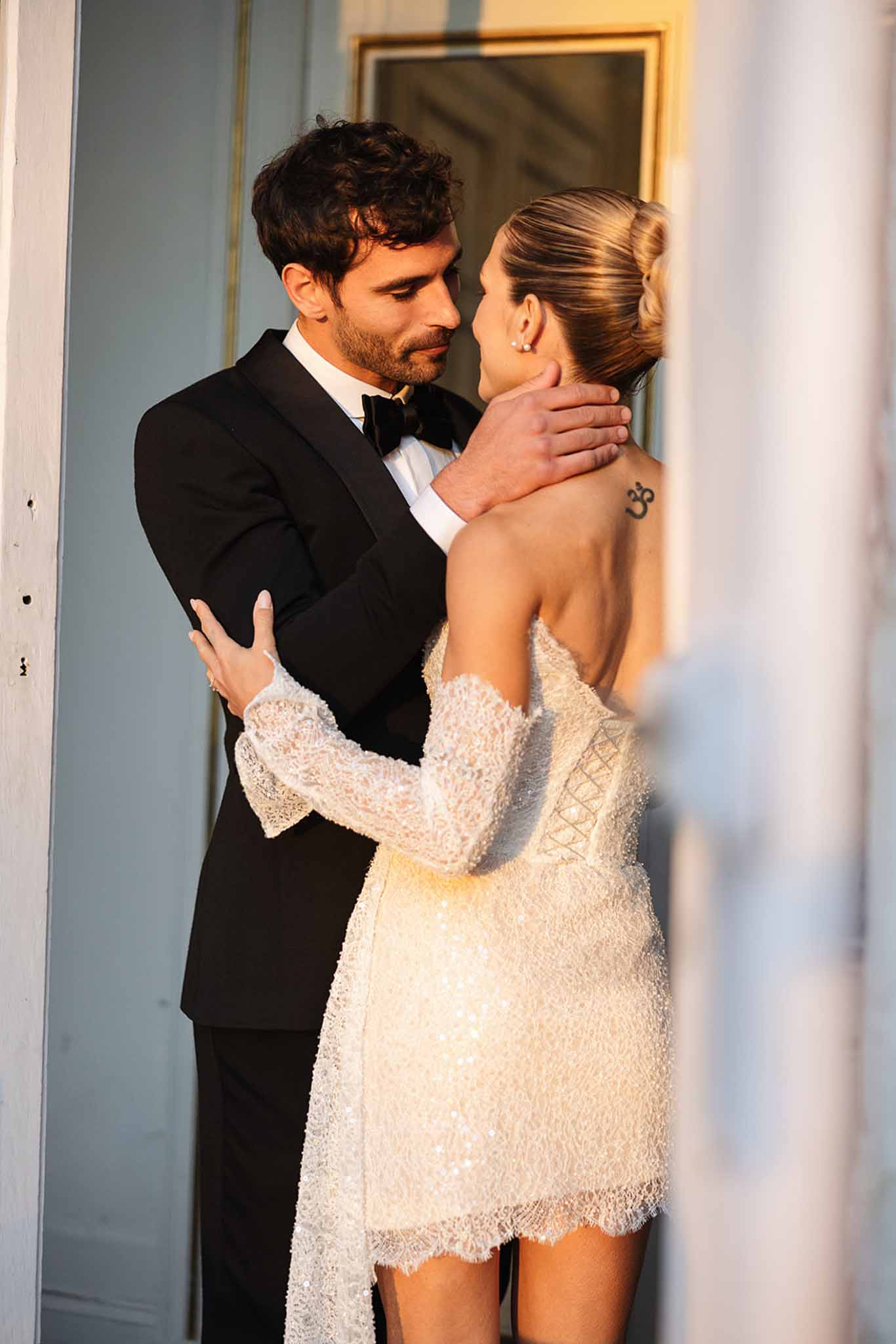 Bride and groom embracing in elegant indoor hallway during intimate portrait session