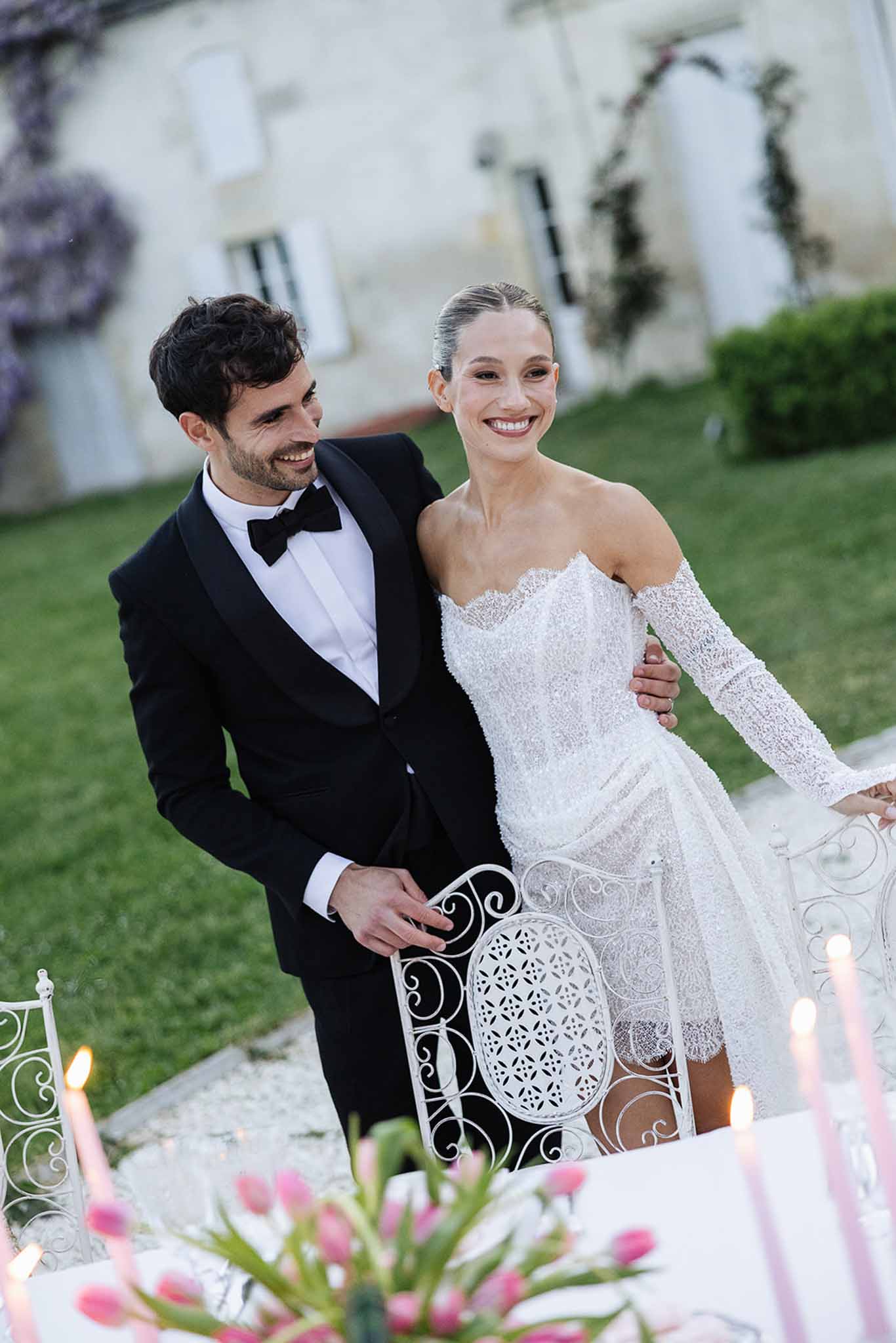 Bride and groom posing together on manicured lawn at wedding reception venue