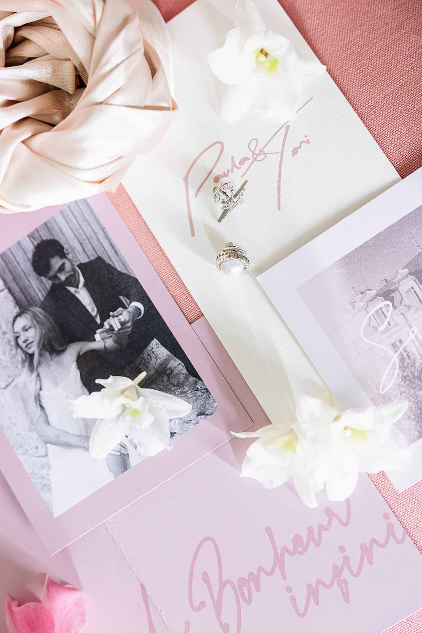 Wedding stationery flat lay with rings and orchids in blush and cream color palette