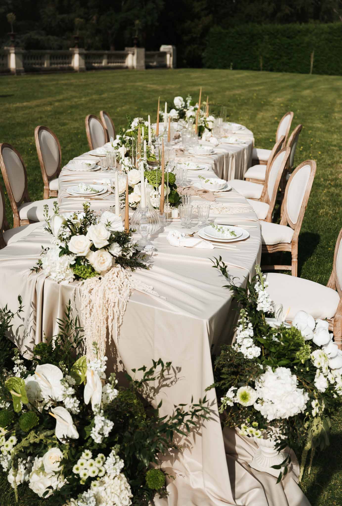 Wedding reception table setting in a garden with white roses