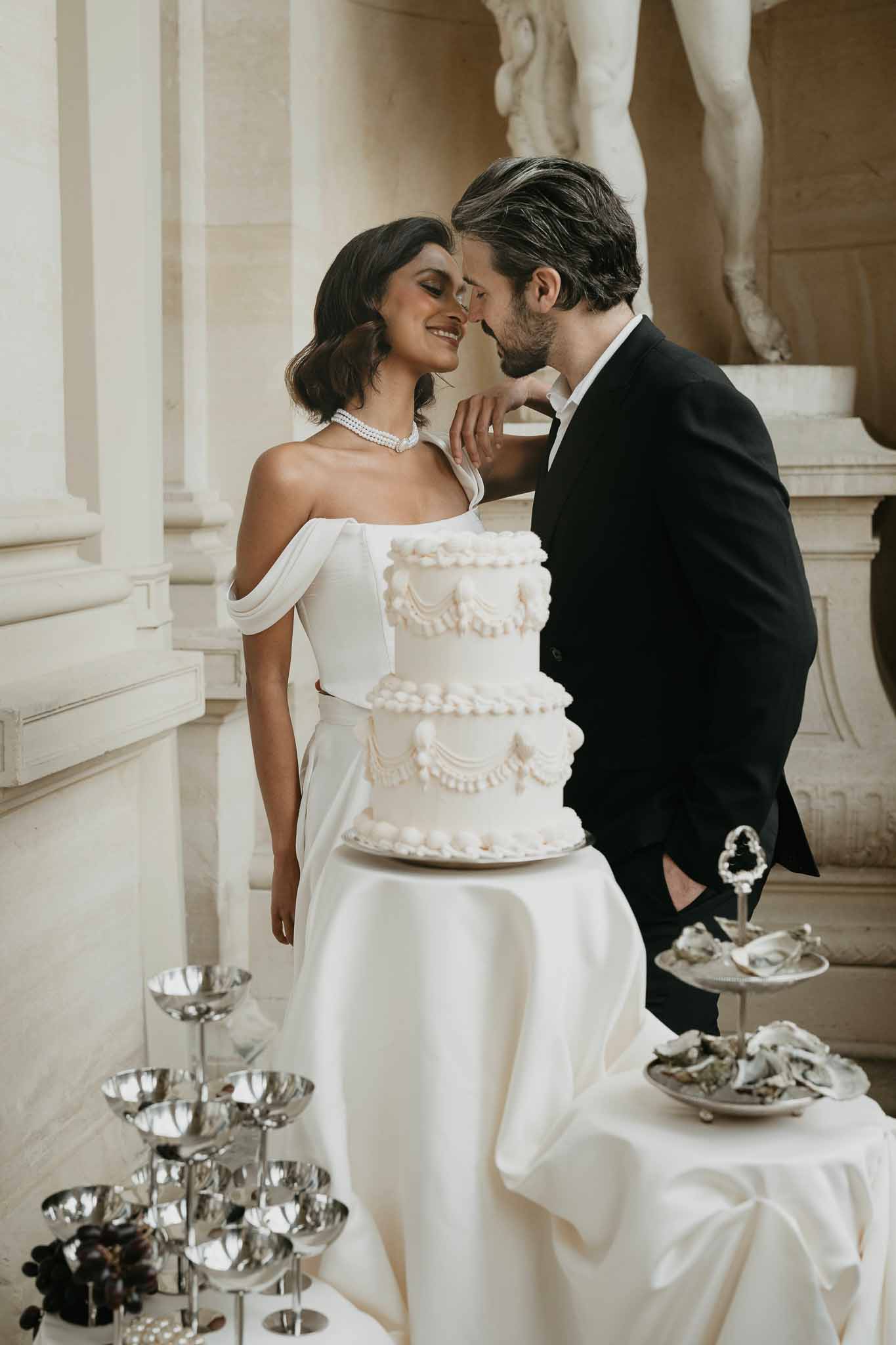 Bride and groom cutting wedding cake at elegant indoor reception venue