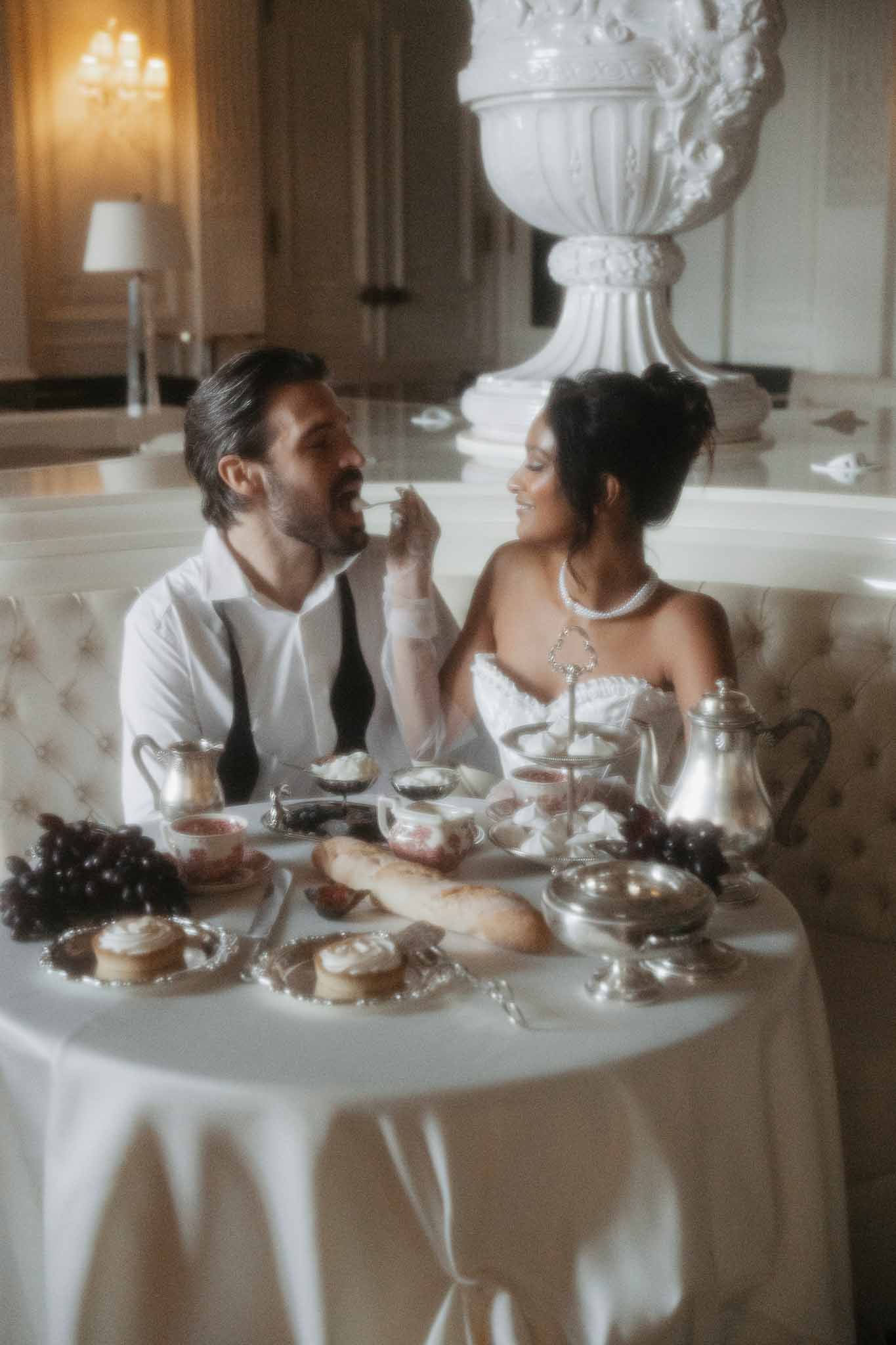 Bride and groom sharing intimate moment at reception table in classical indoor venue