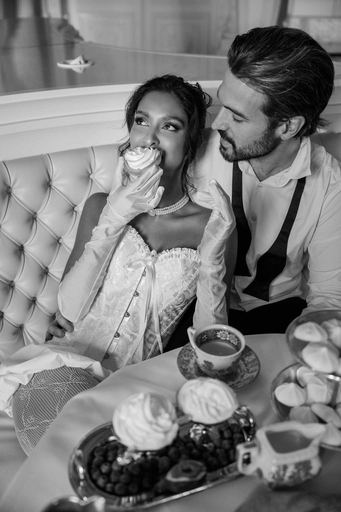 Bride and groom sharing dessert during wedding reception at upscale indoor venue