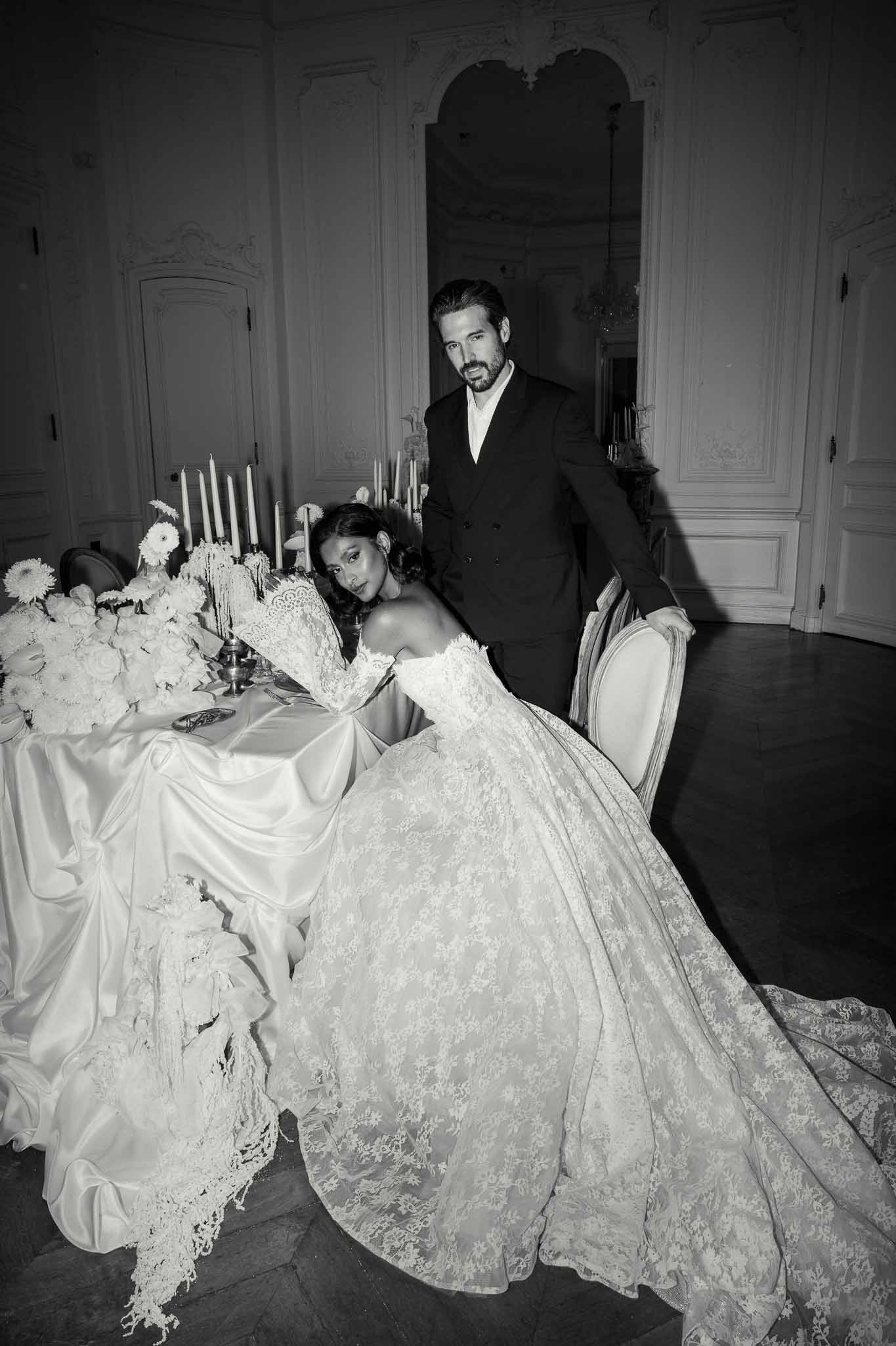 Bride and groom portrait at elegant reception table with floral centerpiece in classical interior