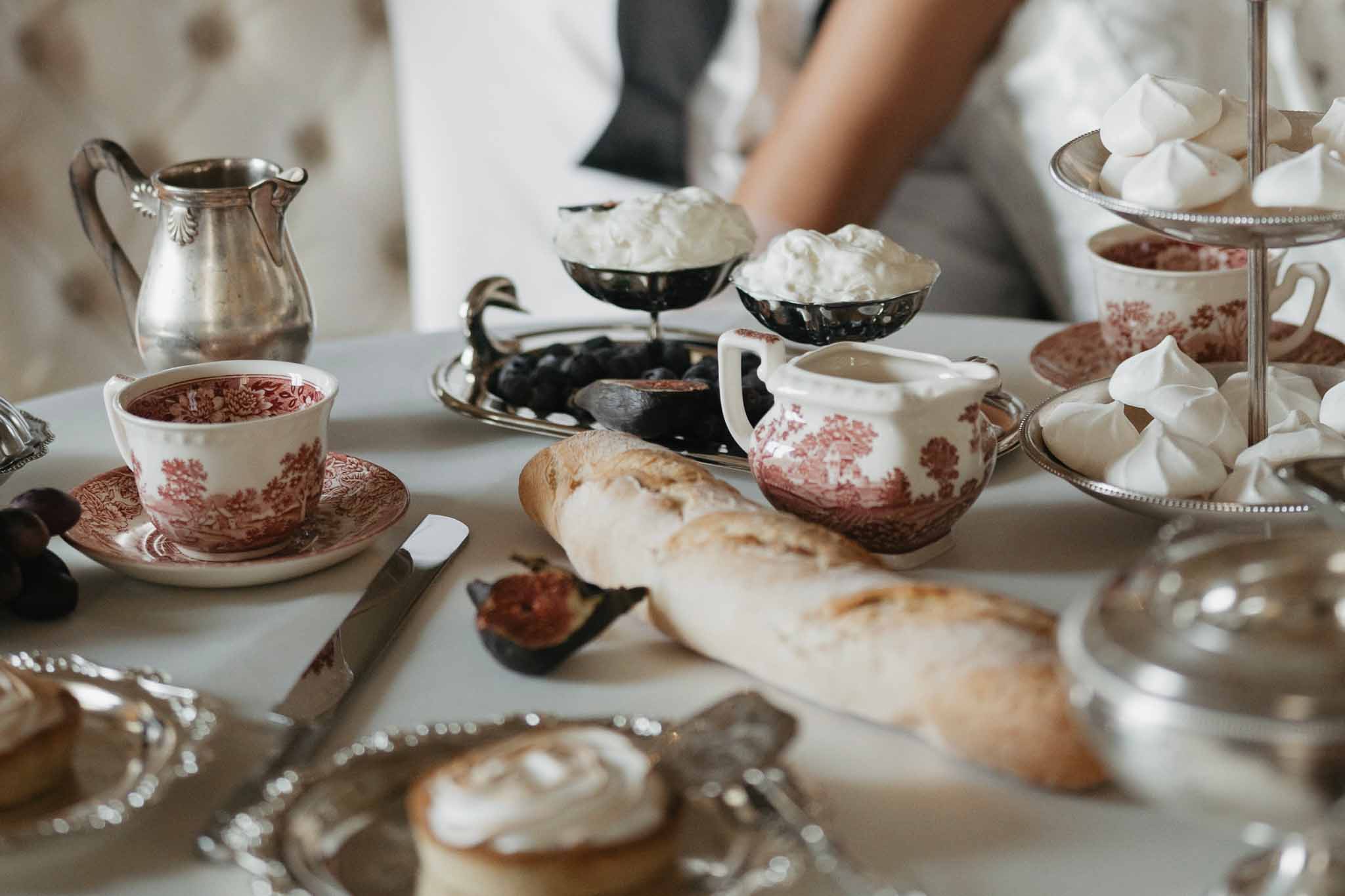 Afternoon tea service with red and white transferware and silver serving pieces at wedding reception